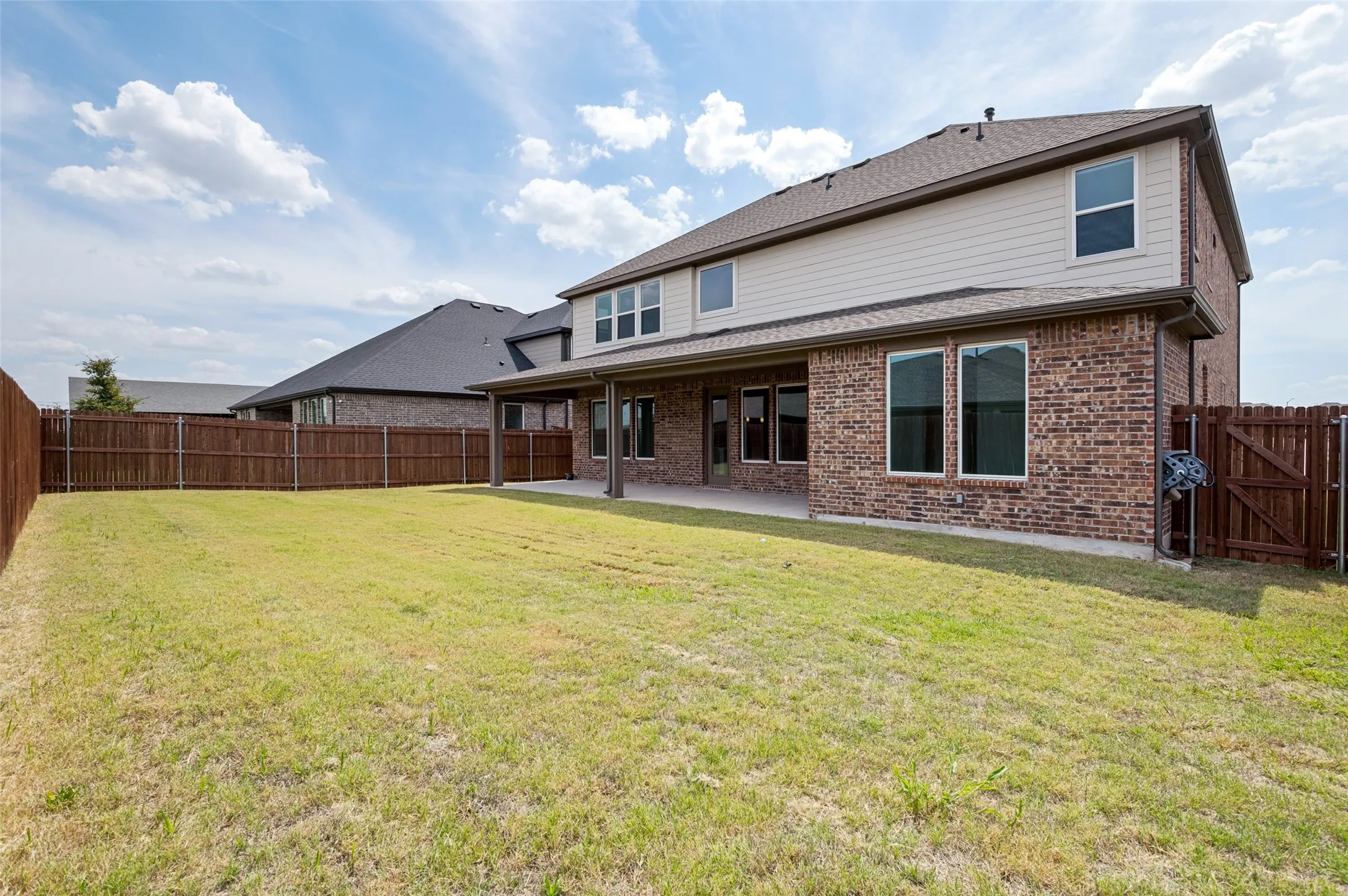 Expansive grass lawn with a full privacy fence