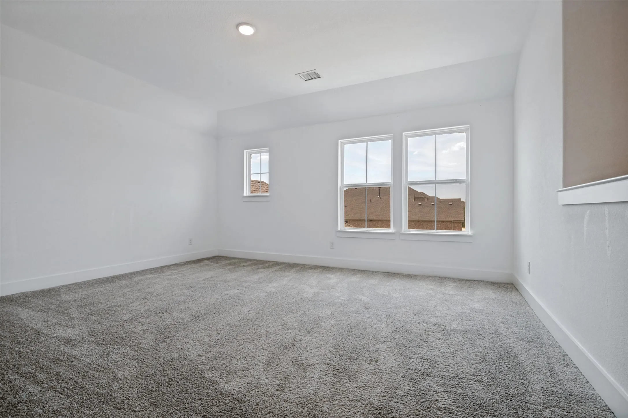 Recessed lighting, tray ceiling, grey carpeting, and white window trim