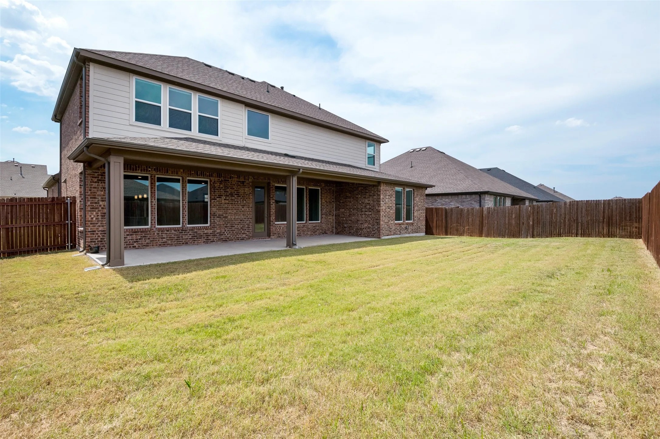 Expansive backyard featuring a large grass area and wood privacy fencing