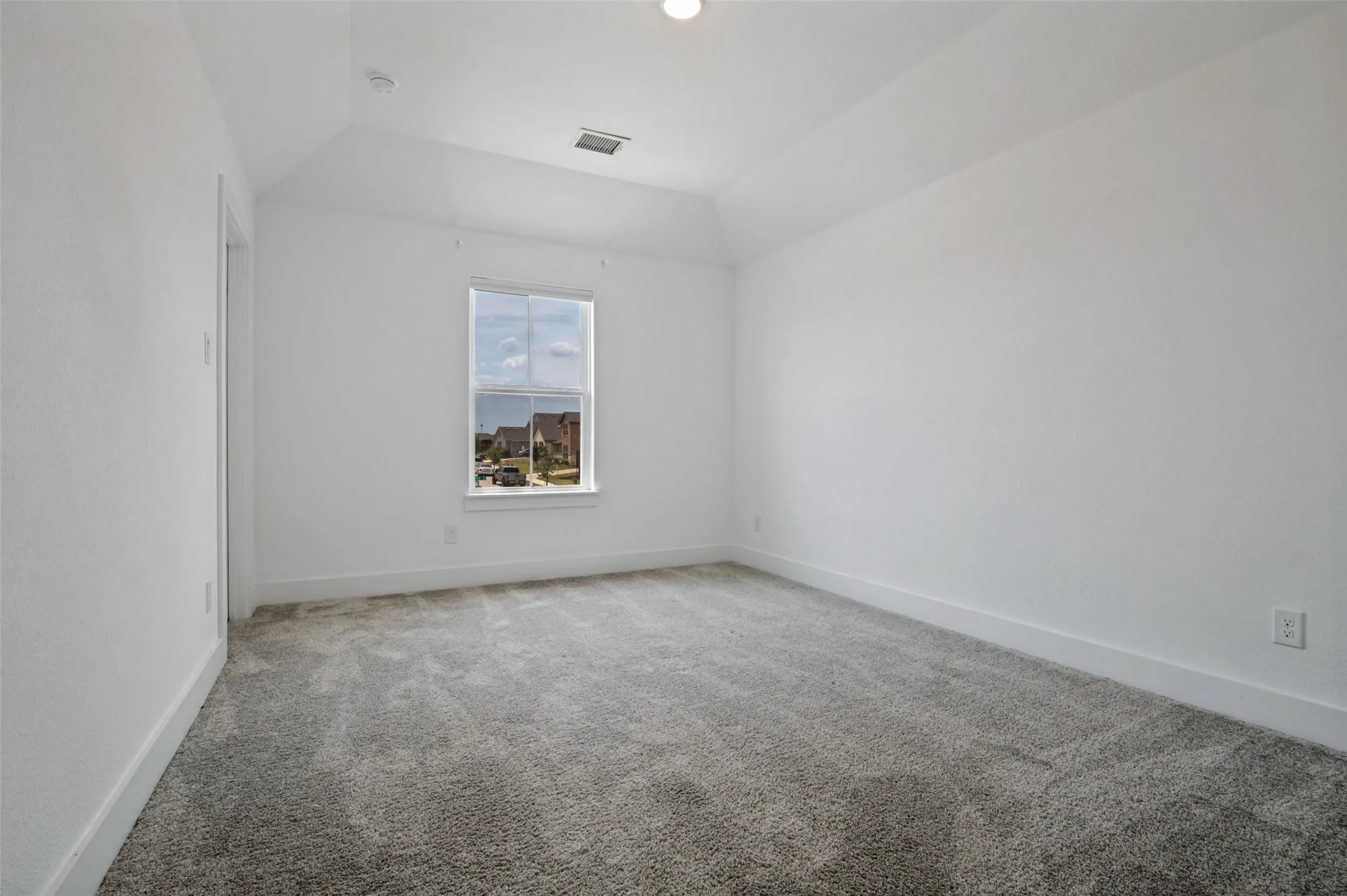 Vaulted ceiling, recessed lighting, double-hung window, wall-to-wall carpeting, and white trim