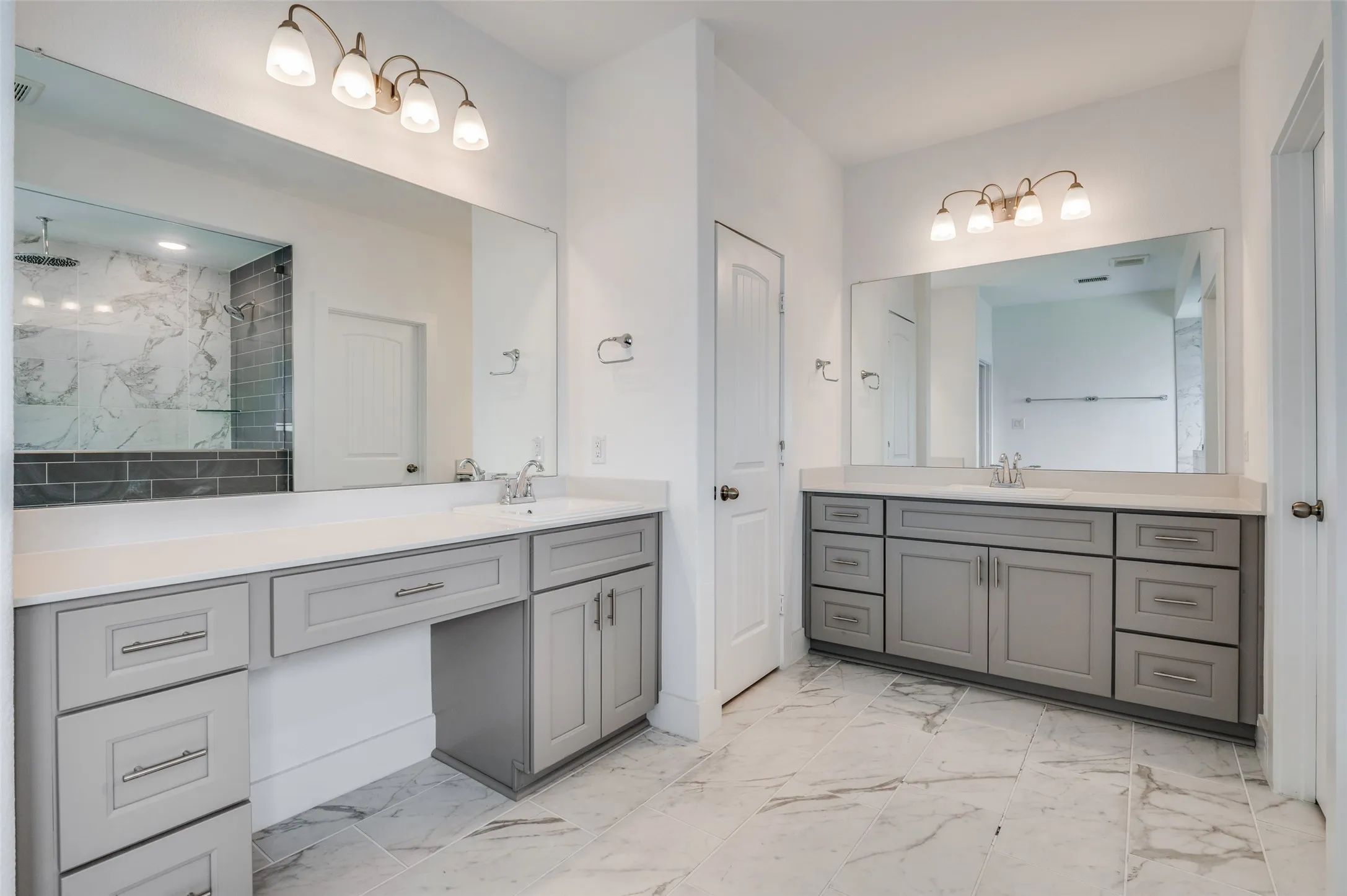 Dual vanities with gray cabinetry and white countertops
