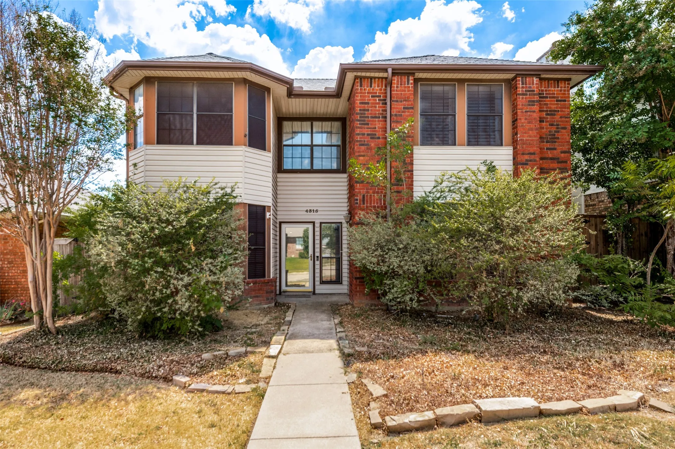 Red brick and siding exterior with multiple windows