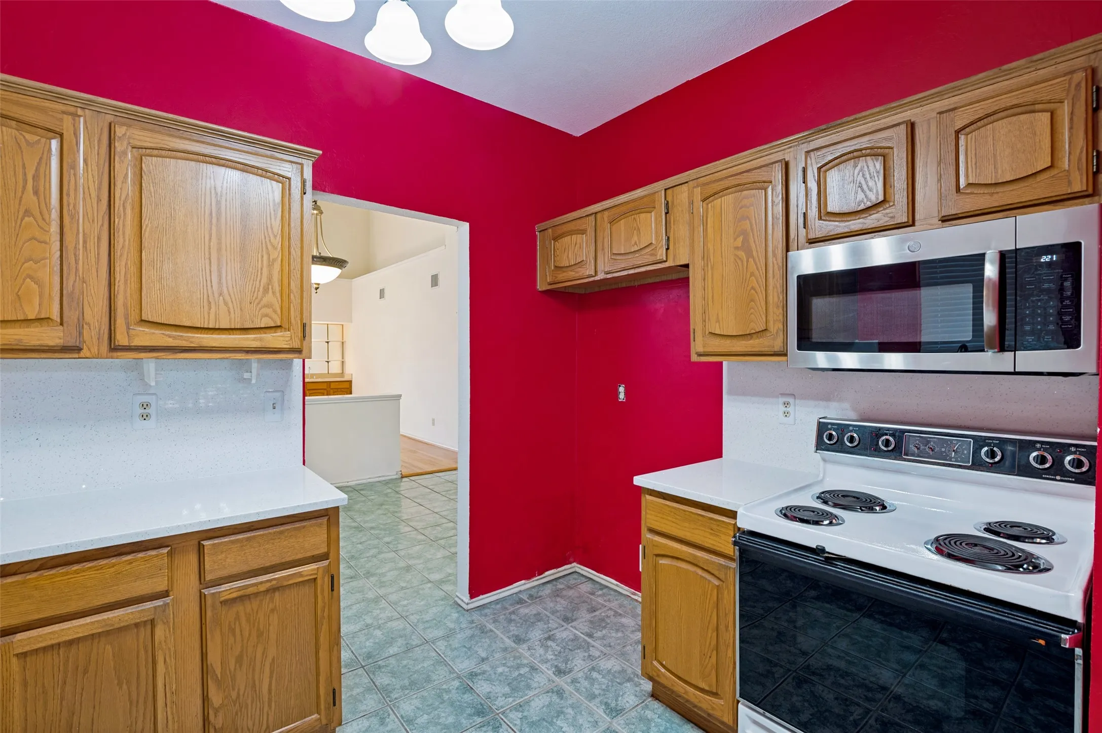 Wood-finish cabinetry paired with white countertops and white tile backsplash