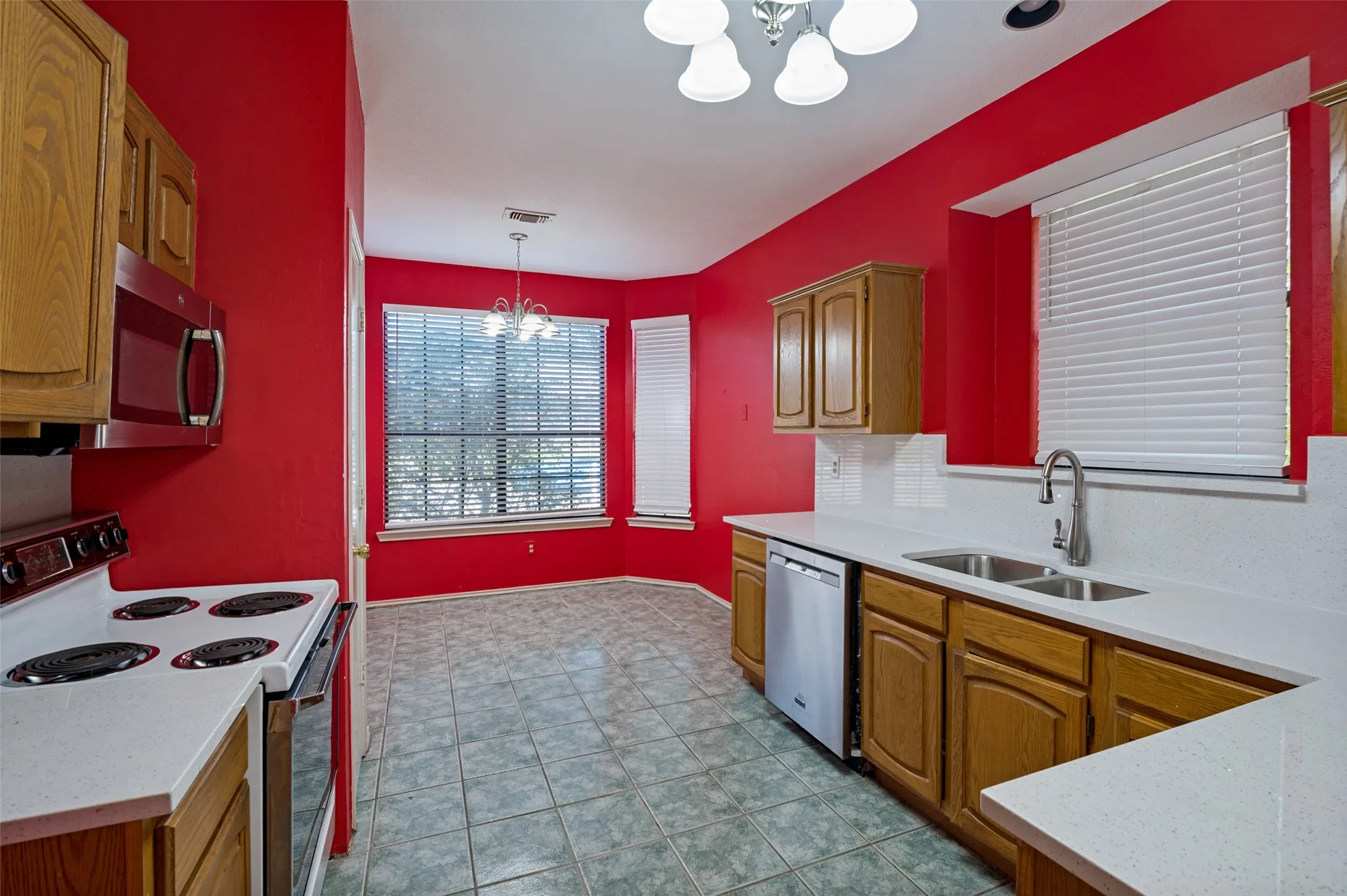 Kitchen featuring wood cabinetry, white countertops, tile flooring, and a stainless steel dishwasher