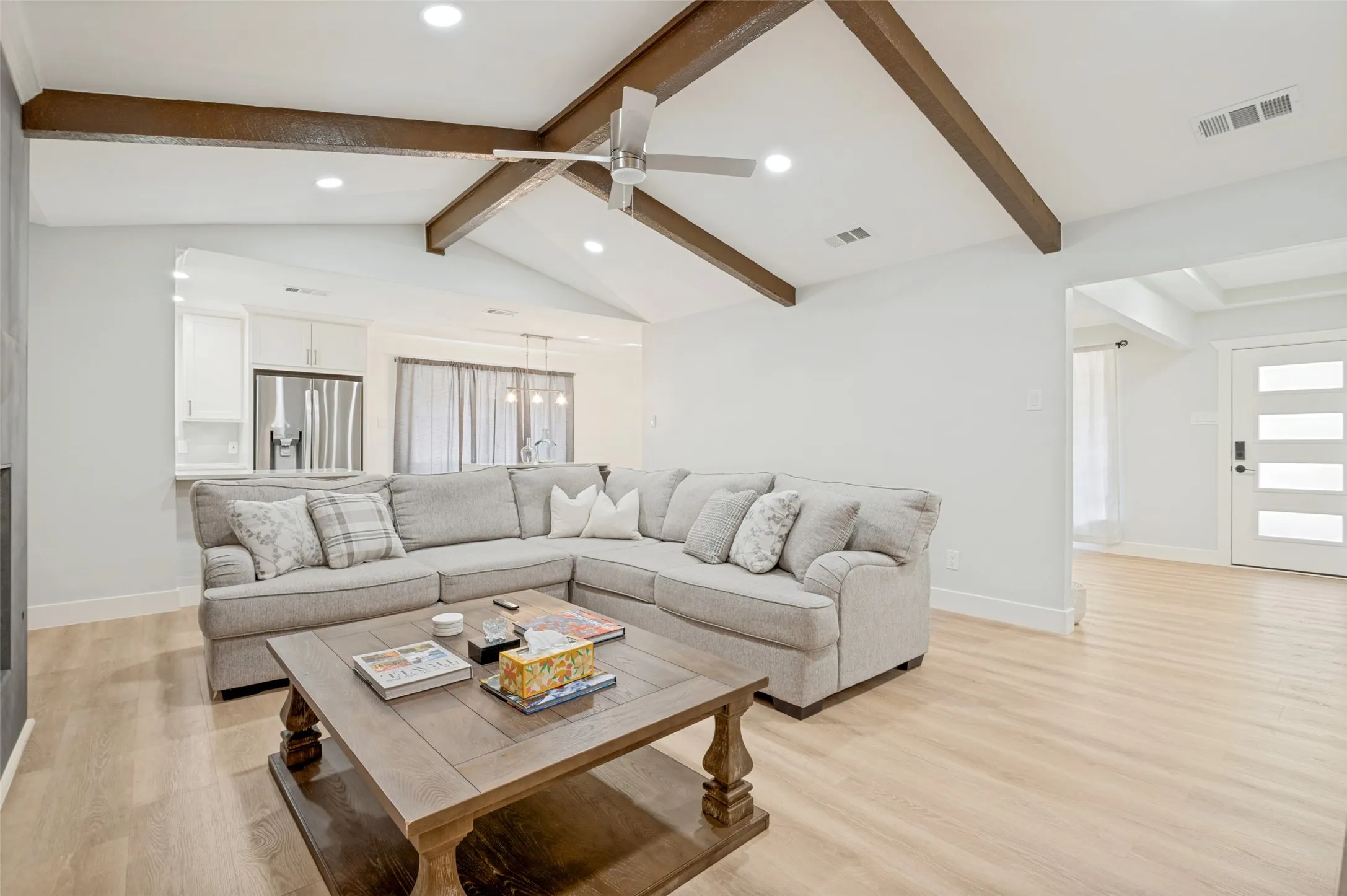 family room features vaulted ceilings with wood beams