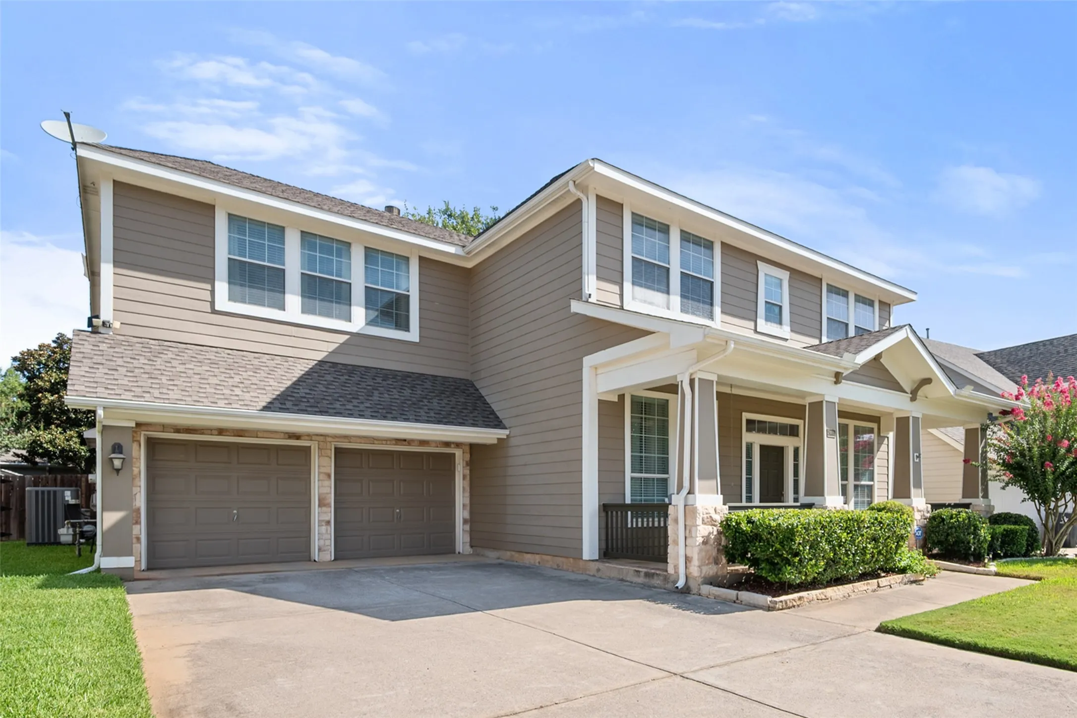 Two-story residence featuring light brown siding and white trim