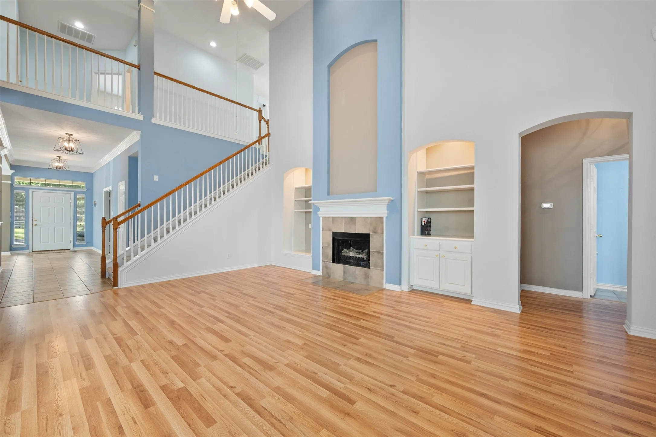 Large open living room with gas fireplace and built in shelves