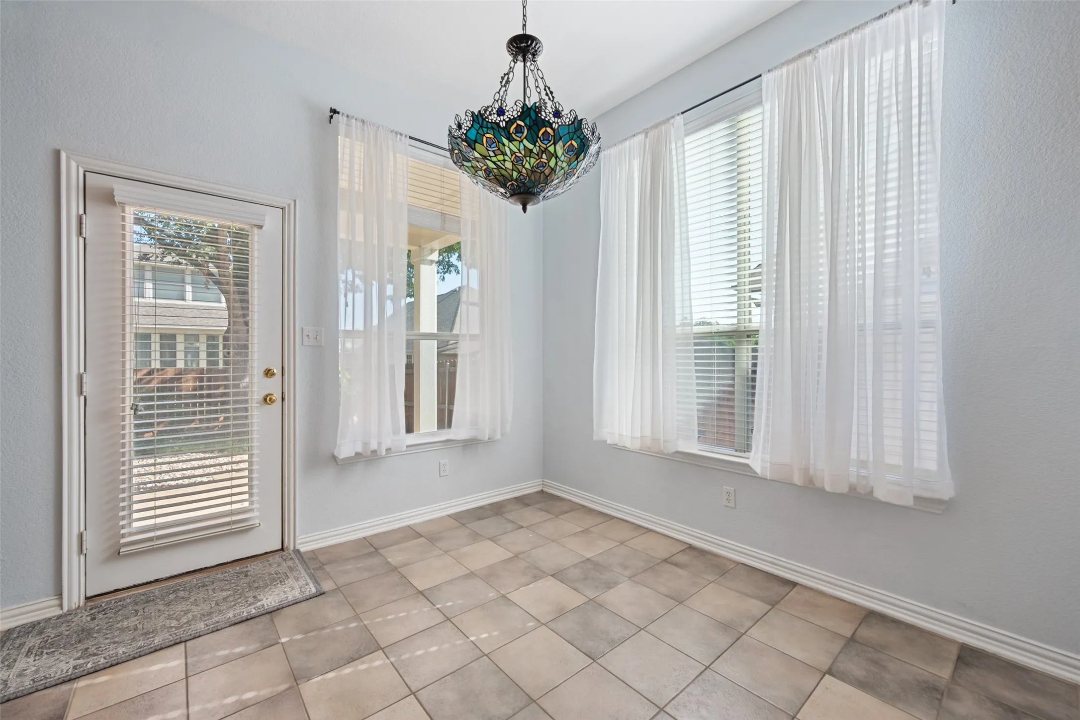 Bright breakfast room showcasing a peacock decorative pendant light fixture overhead because its in Fannin Farm and if you know you know!
