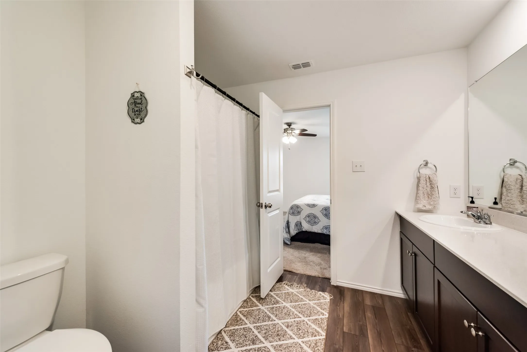 Bathroom featuring a single vanity with dark wood-finish cabinetry, a white countertop, and an integrated sink