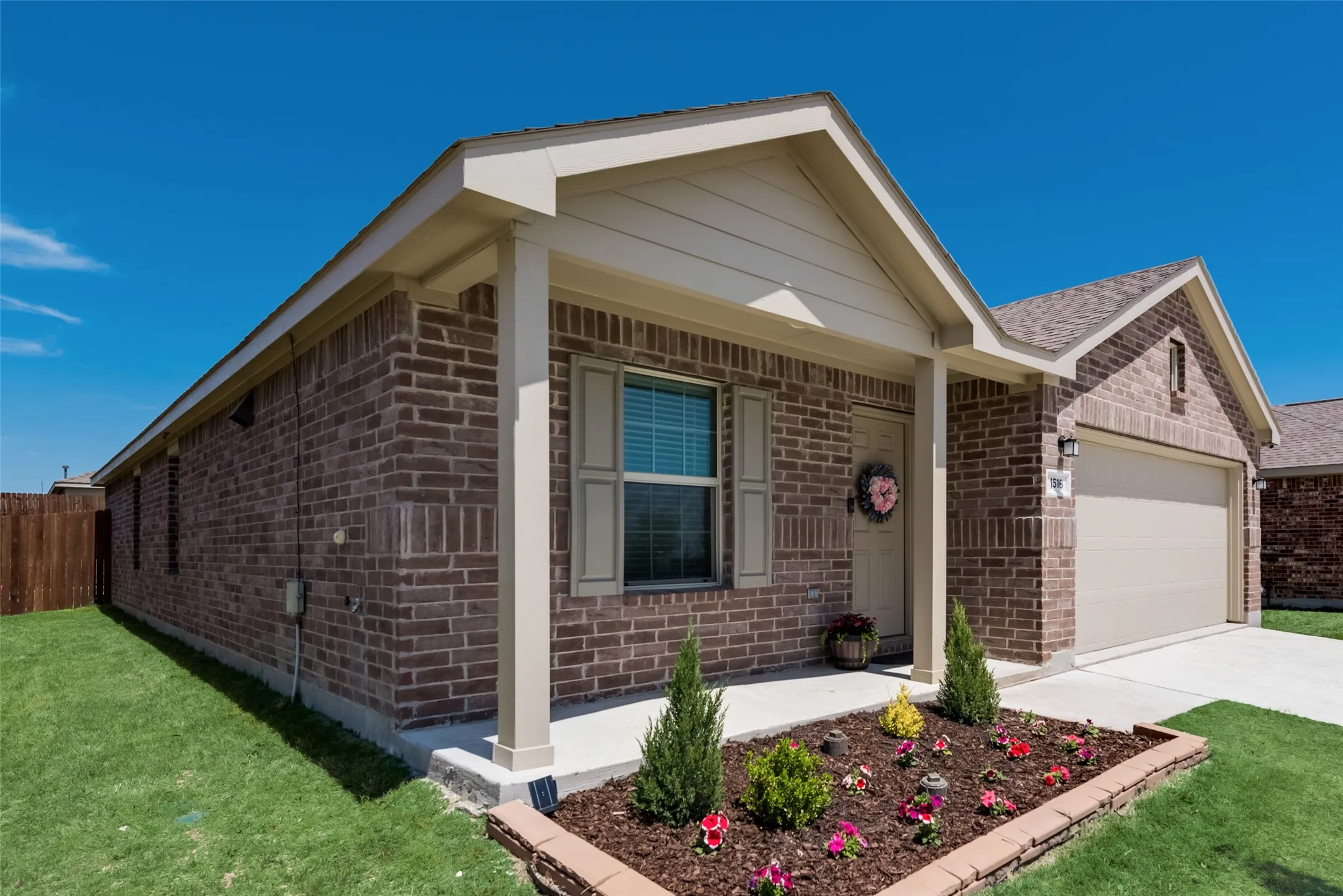 Brick exterior with a covered front porch and a landscaped front garden bed