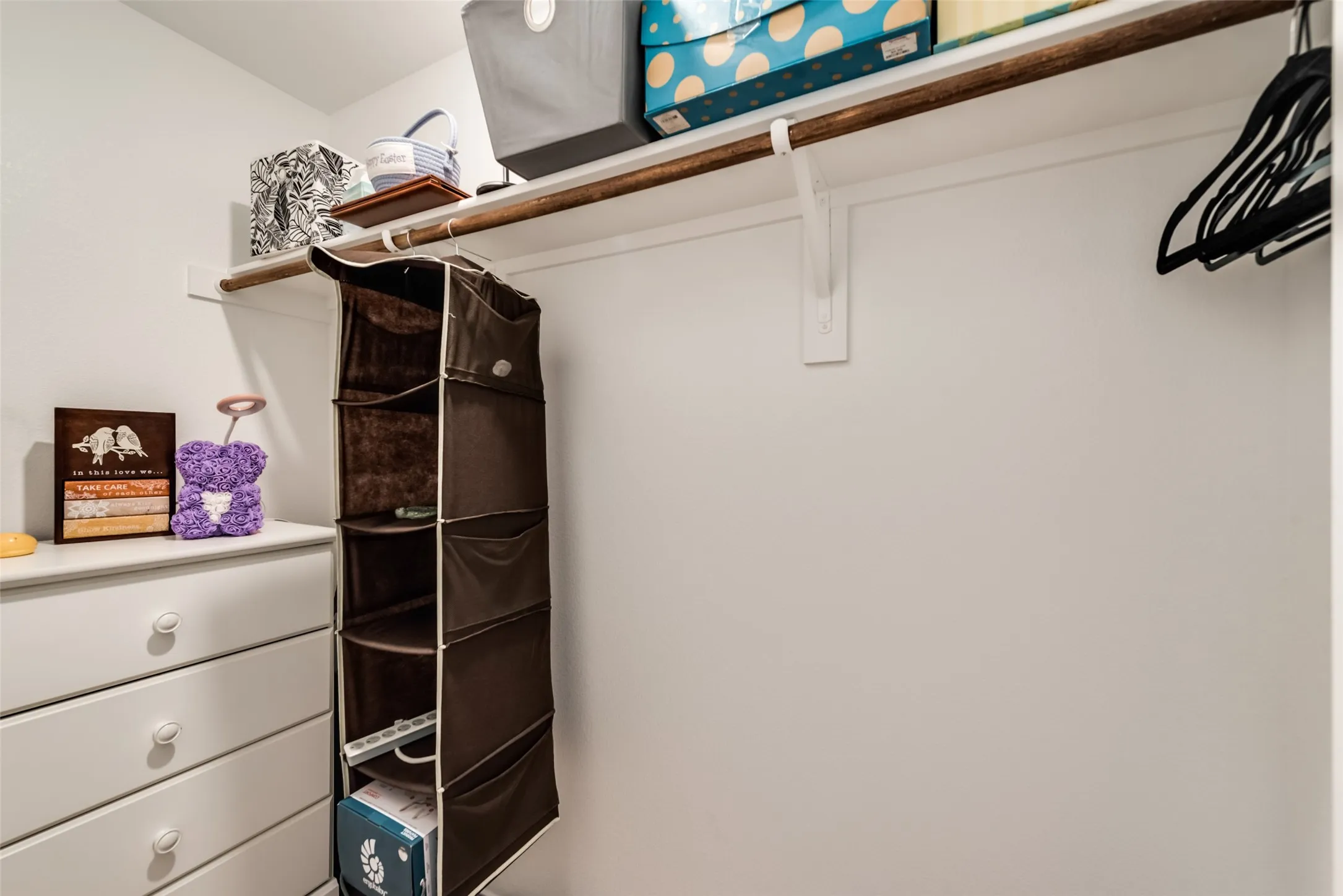 Built-in shelving unit with an integrated clothing rod and additional storage drawers
