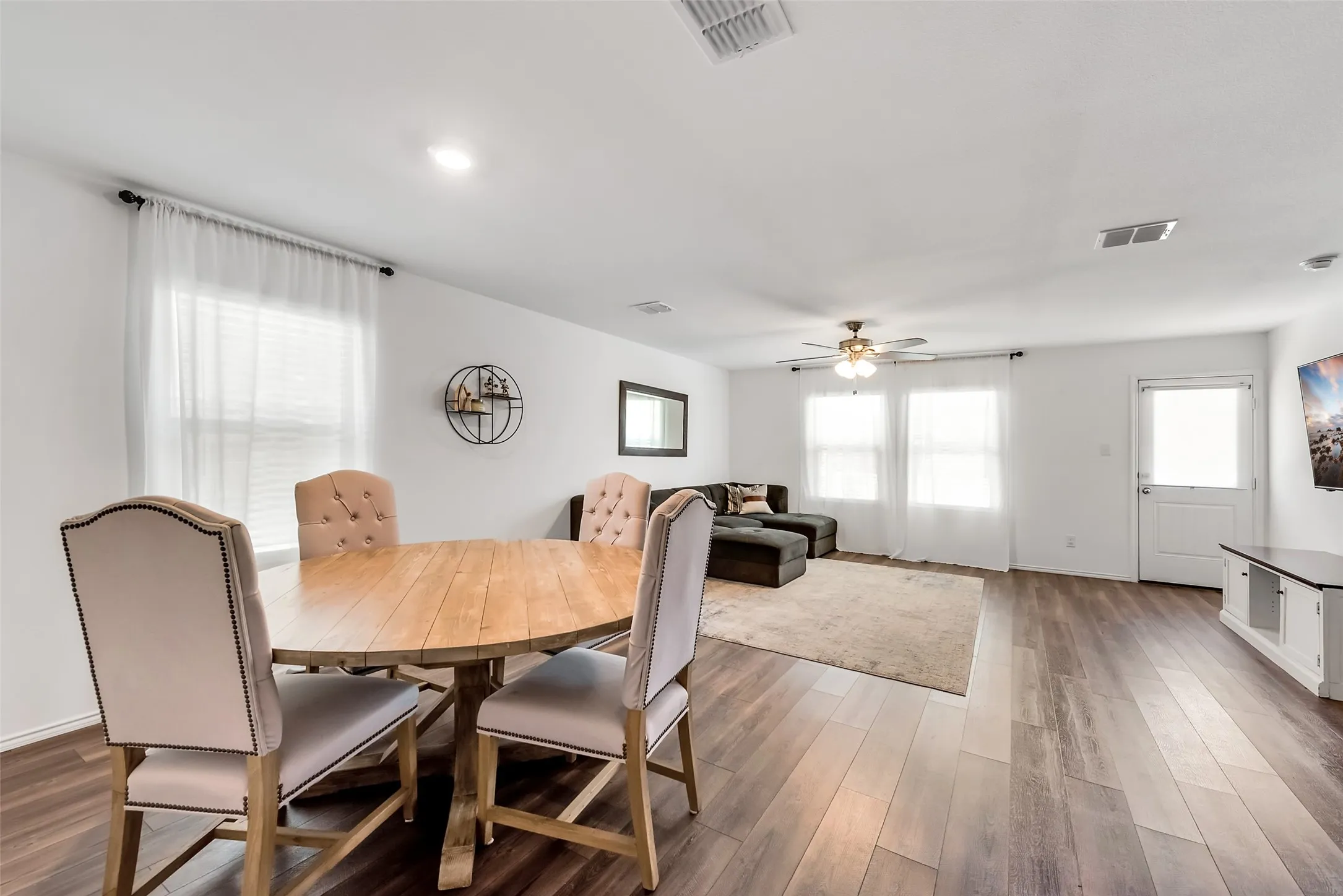 Spacious living area featuring wood-finish flooring, recessed lighting, and a ceiling fan