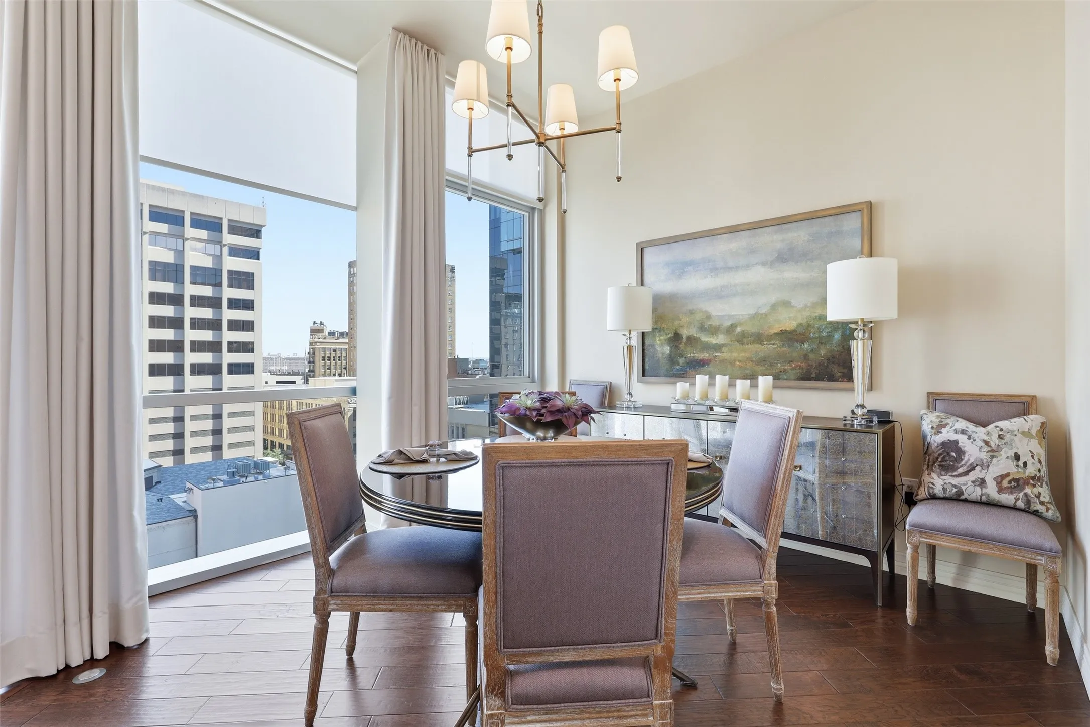 Expansive window wall with city backdrop, wood-finish flooring, and a modern chandelier