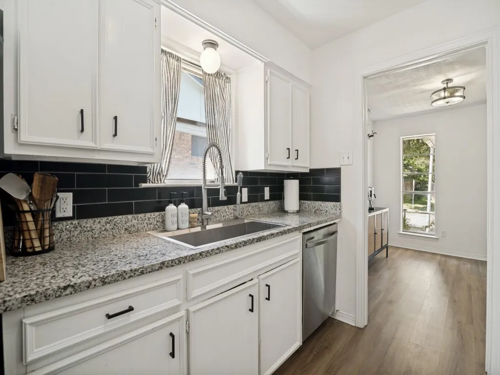 Farm sink with window, updated backsplash and dishwasher on this side of the kitchen.