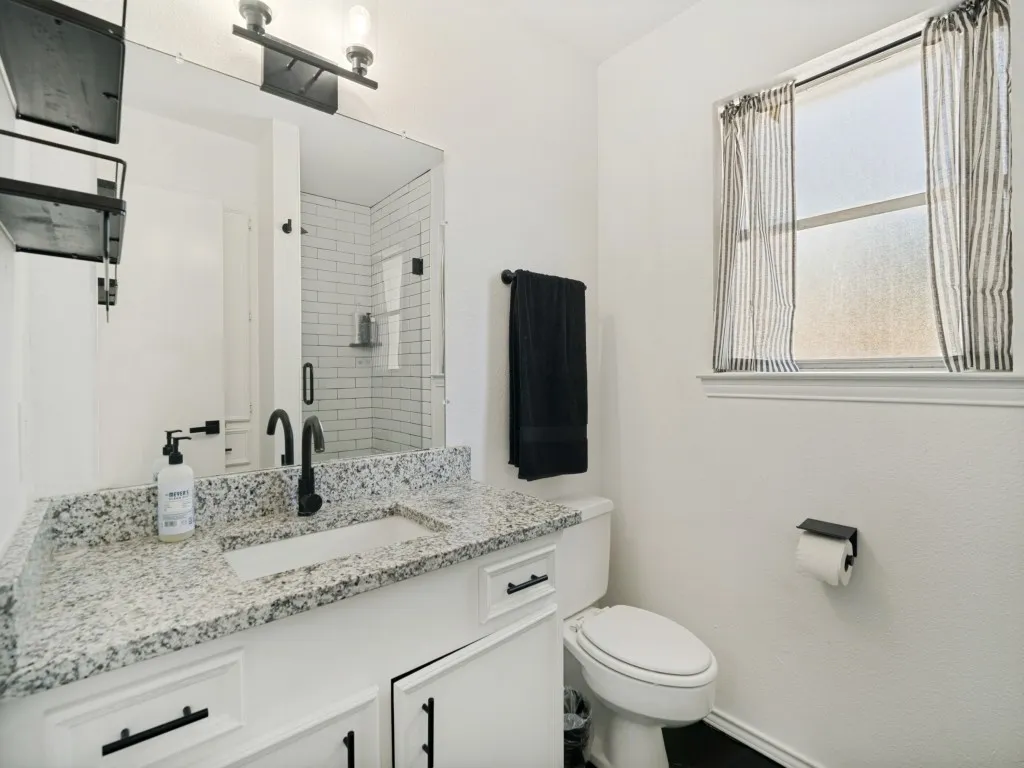 Master bath with granite top and tiled shower with glass door.