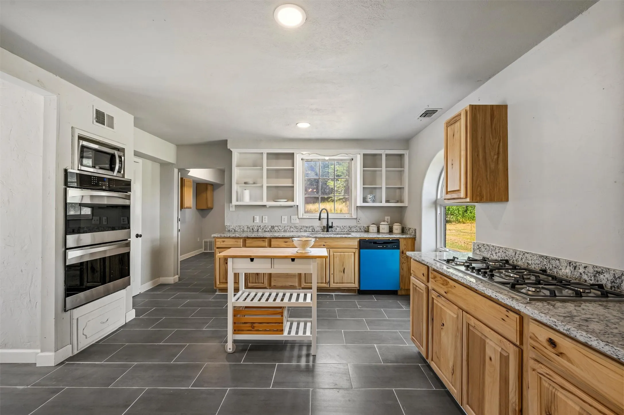 Large kitchen with stainless steel appliances and granite countertops.
