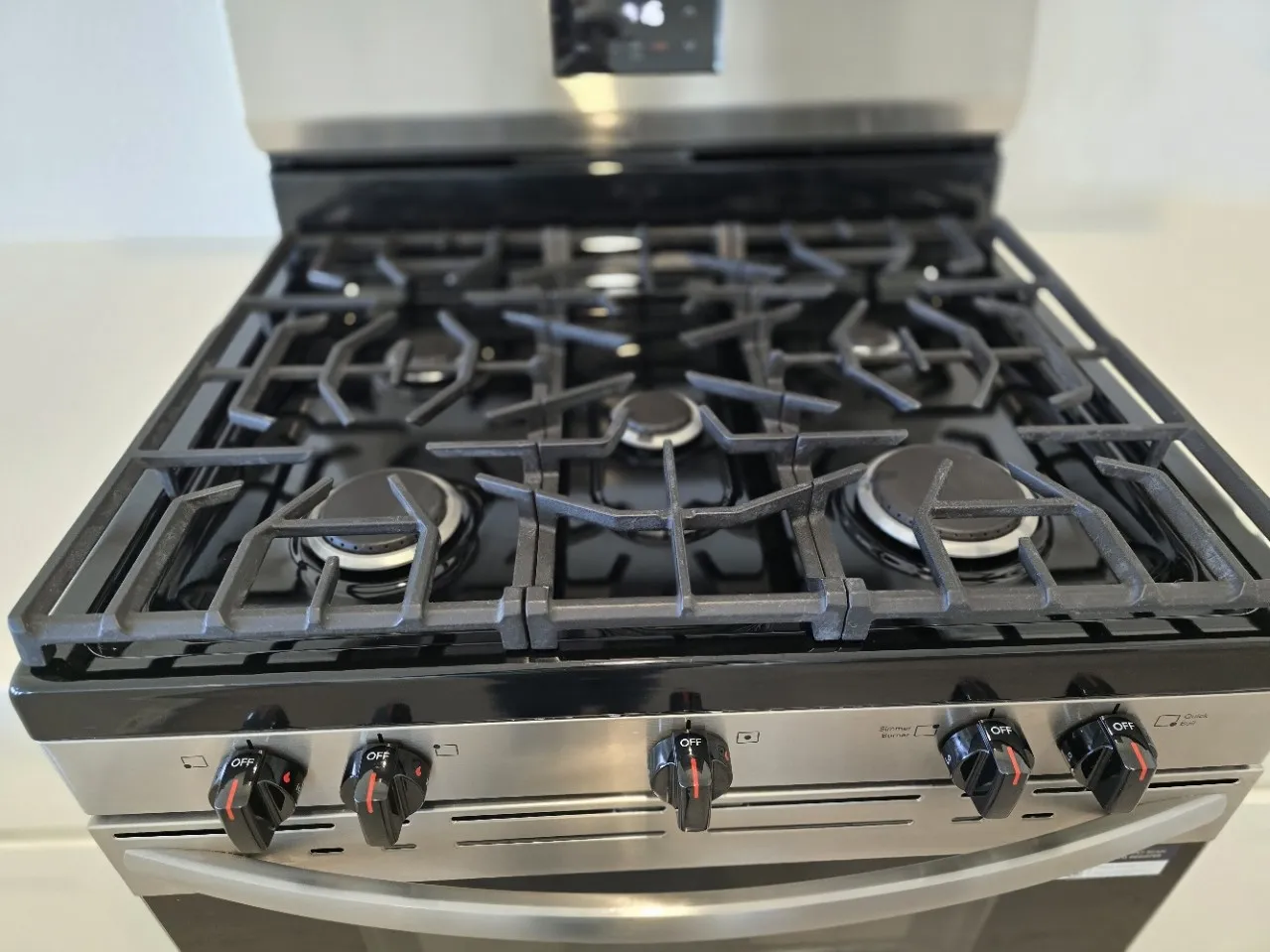 Stainless steel gas range with a black enamel cooktop and cast iron grates