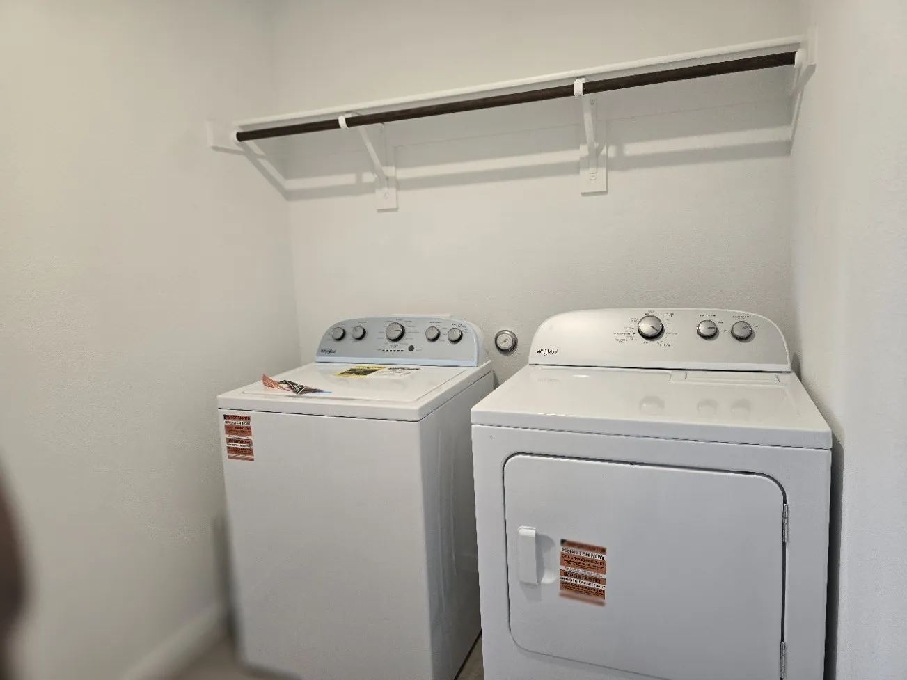 Laundry room on 1st floor - White washer and dryer appliances remain with upper shelving