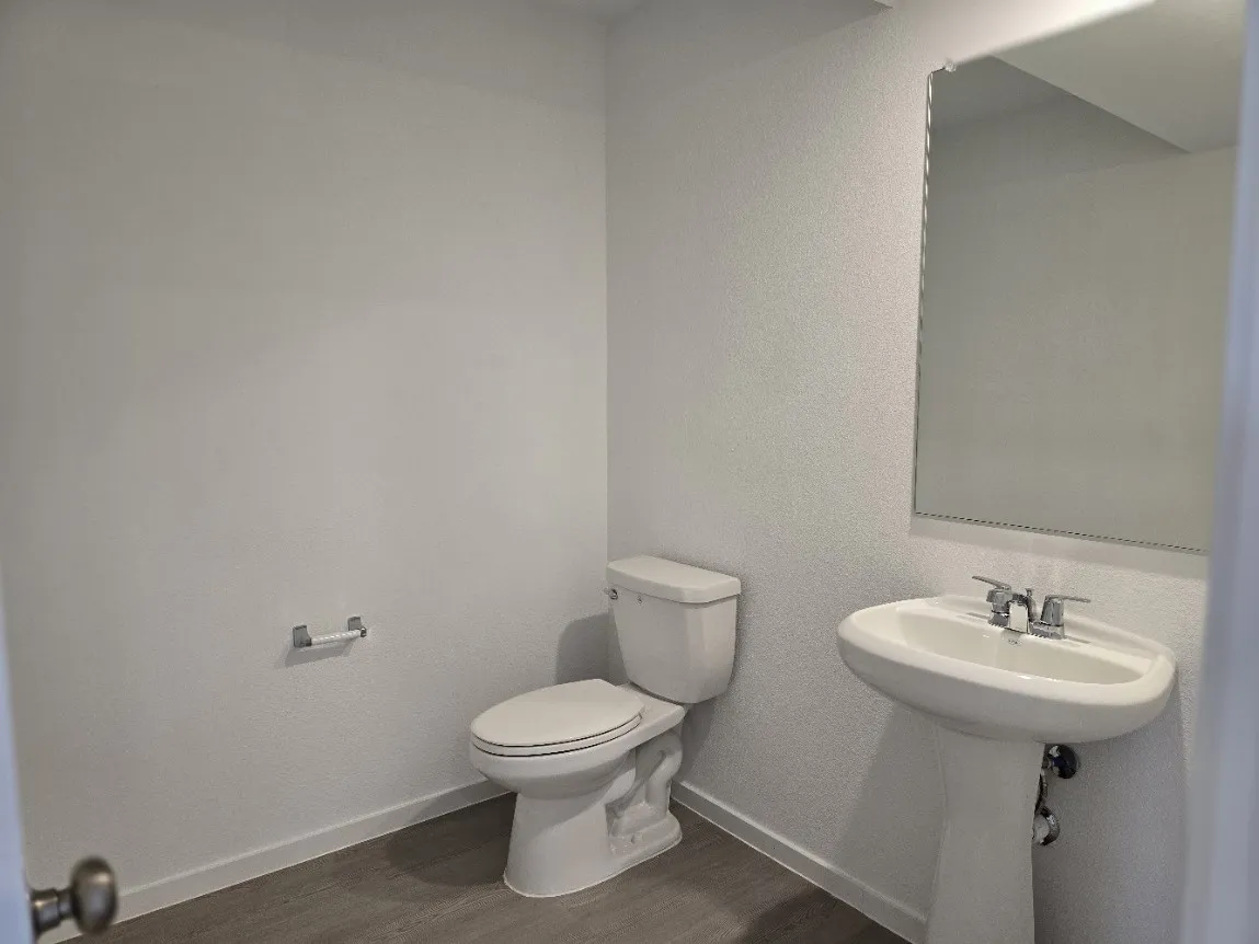 Half bathroom on 1st floor, pedestal sink with chrome fixtures, LVP flooring.  Room for floor standing shelving and cabinets