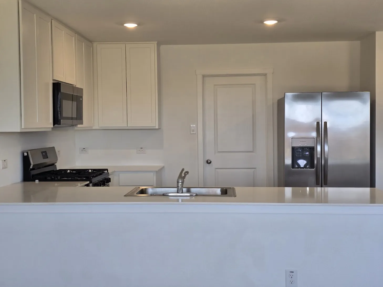 Modern kitchen featuring stainless steel appliances, white cabinetry, a built-in microwave, and a gas range, quartz counter tops
