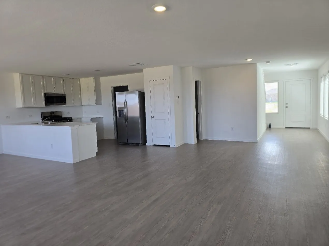 View from Living Room into kitchen area, view to the front entry door, LVP flooring throughout