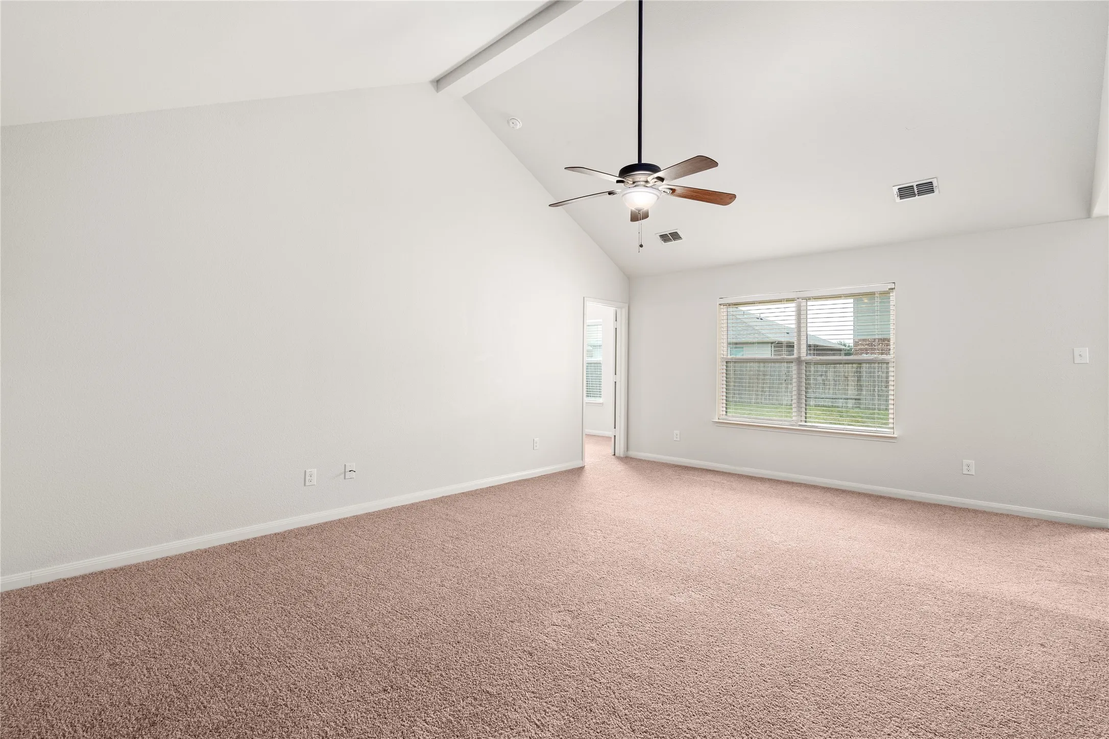 Vaulted ceiling, ceiling fan, carpet flooring, window with blinds, and white wall finishes
