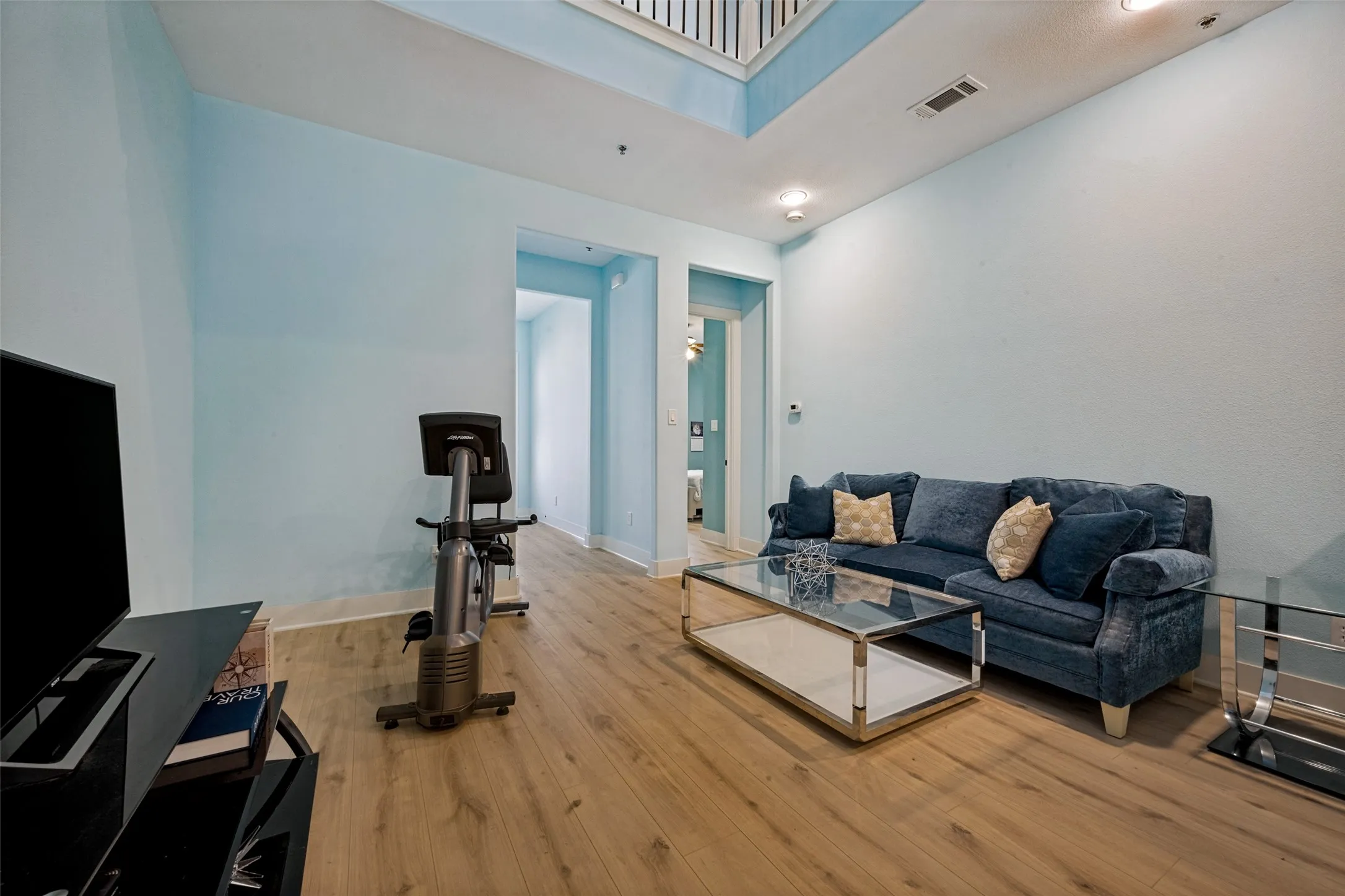 LVP flooring throughout, recessed ceiling lighting, and a high ceiling