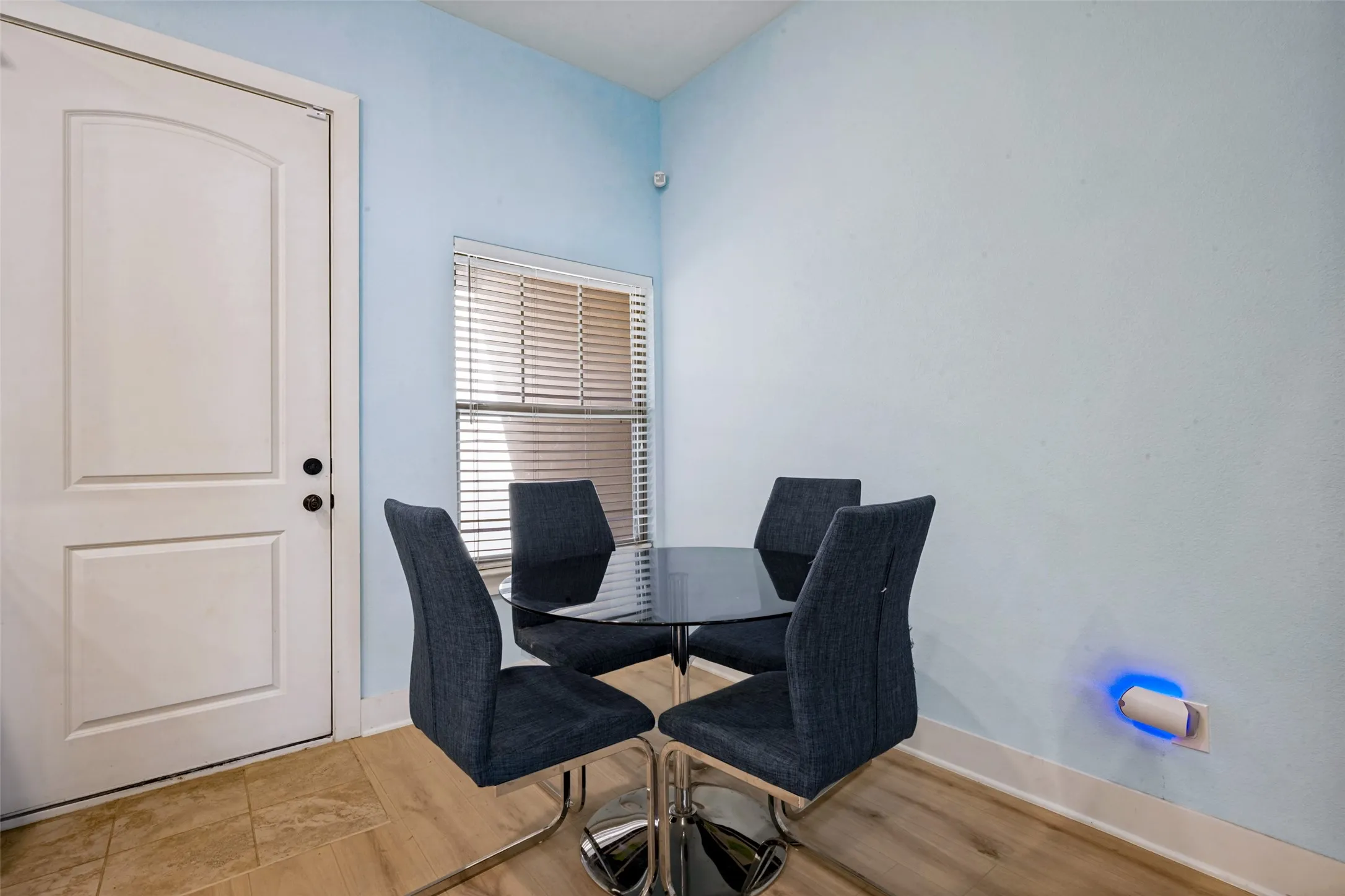 Window with horizontal blinds, providing natural light in the dining area