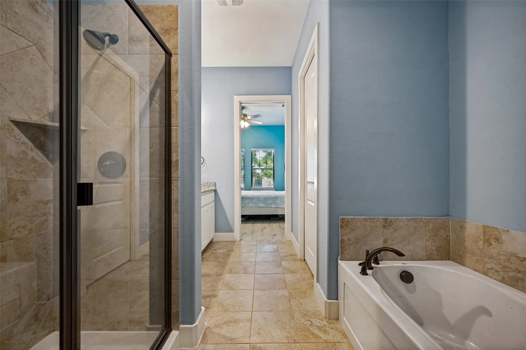 Walk-in shower with clear glass enclosure and tile surround