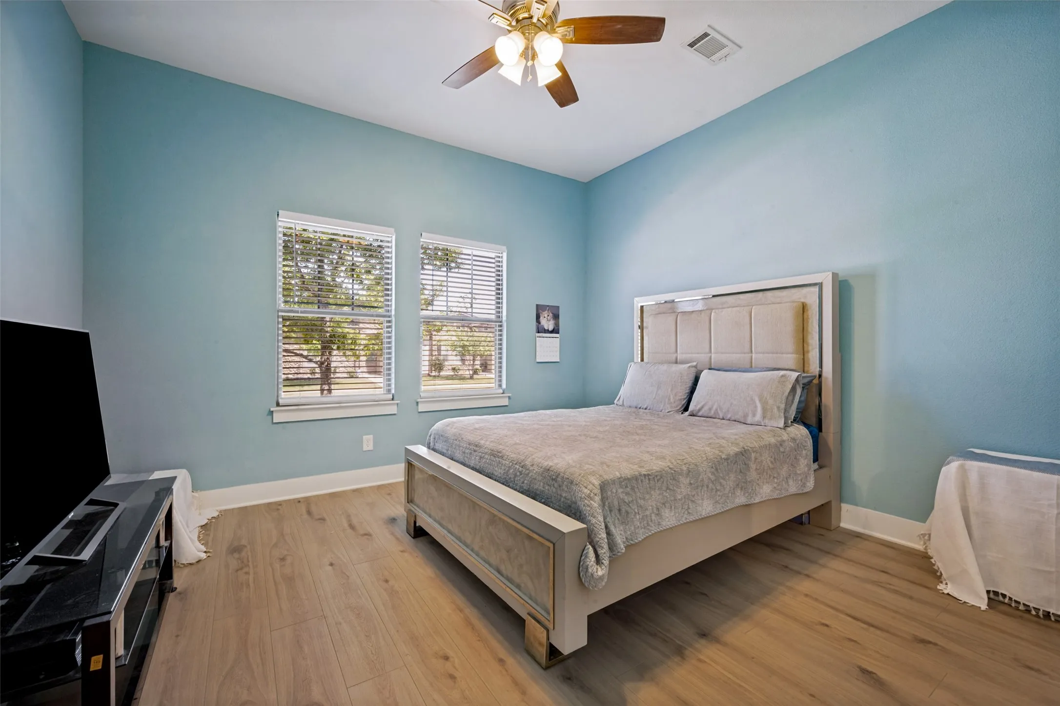 New LVP  flooring, two large windows with blinds, ceiling fan with integrated lighting