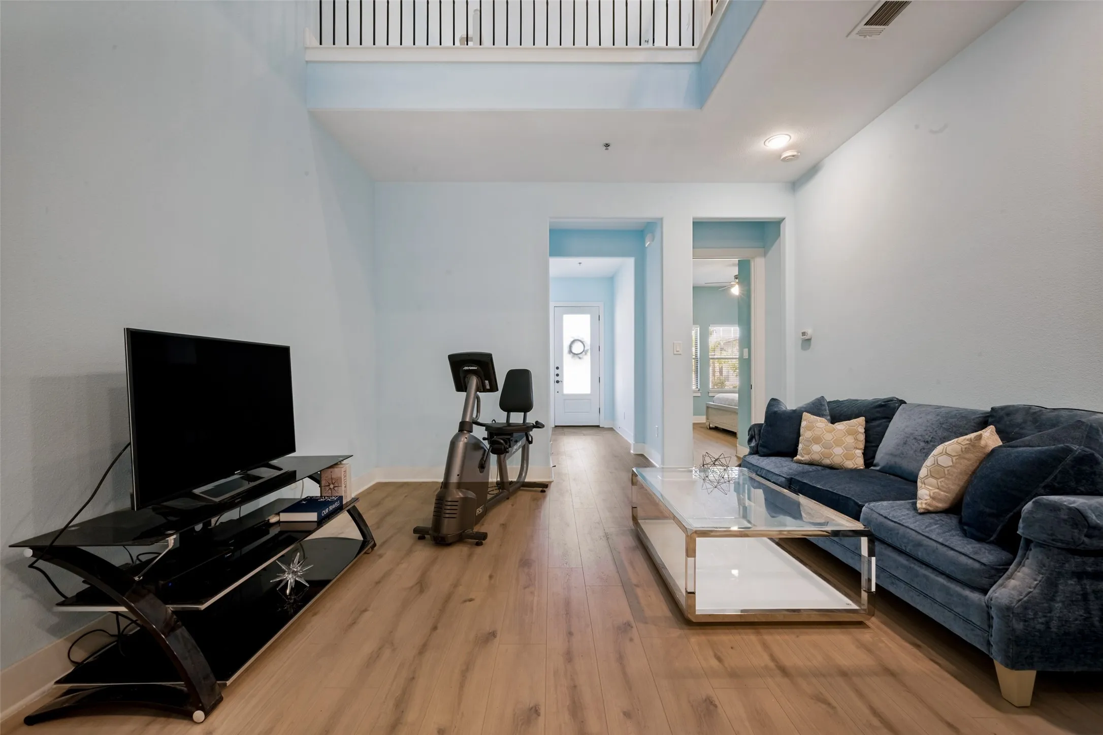 High ceilings, new LVP flooring, recessed lighting, and a white interior door with a transom window