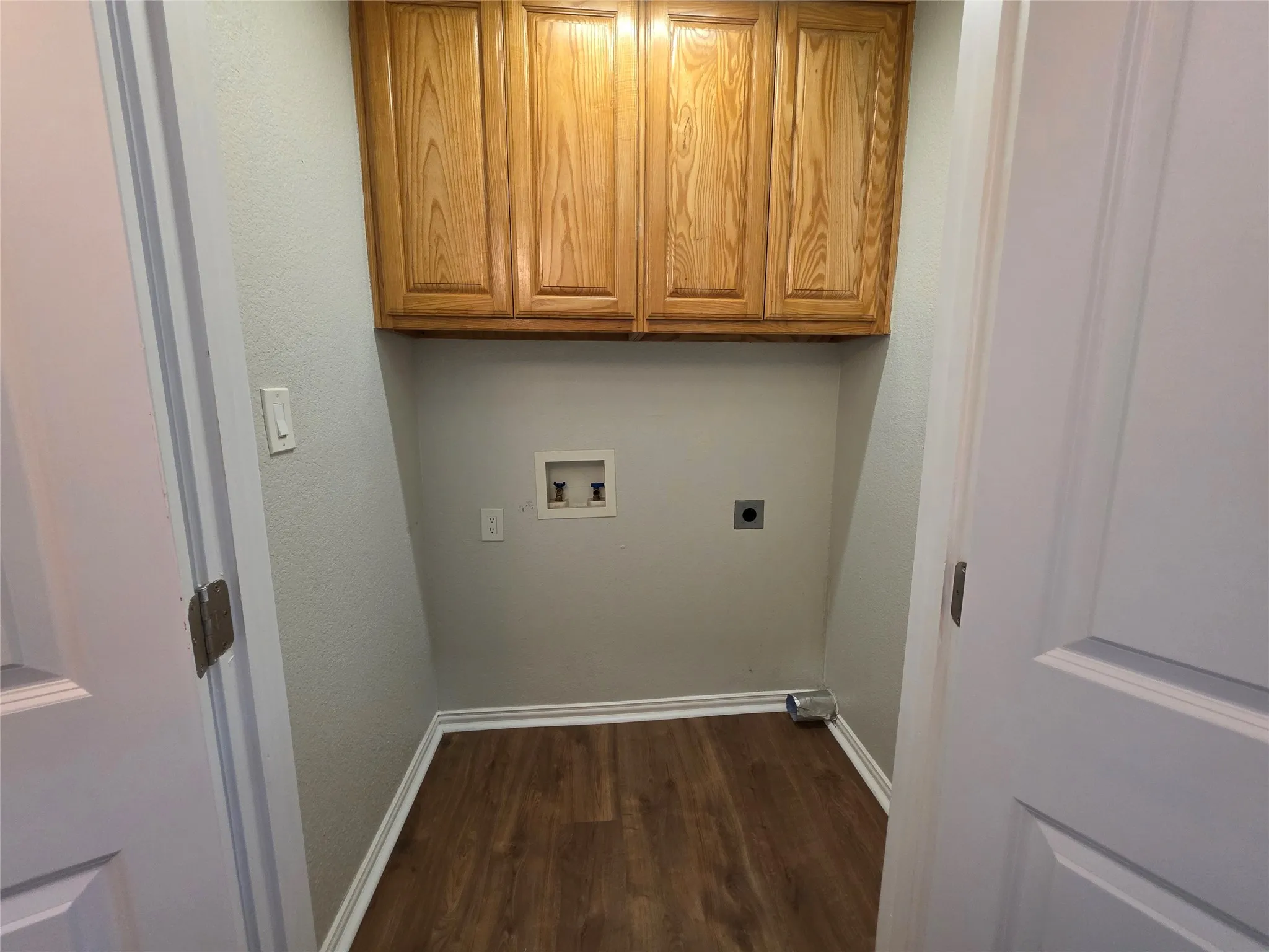 Separate laundry room with upper cabinets and full size washer and dryer connections