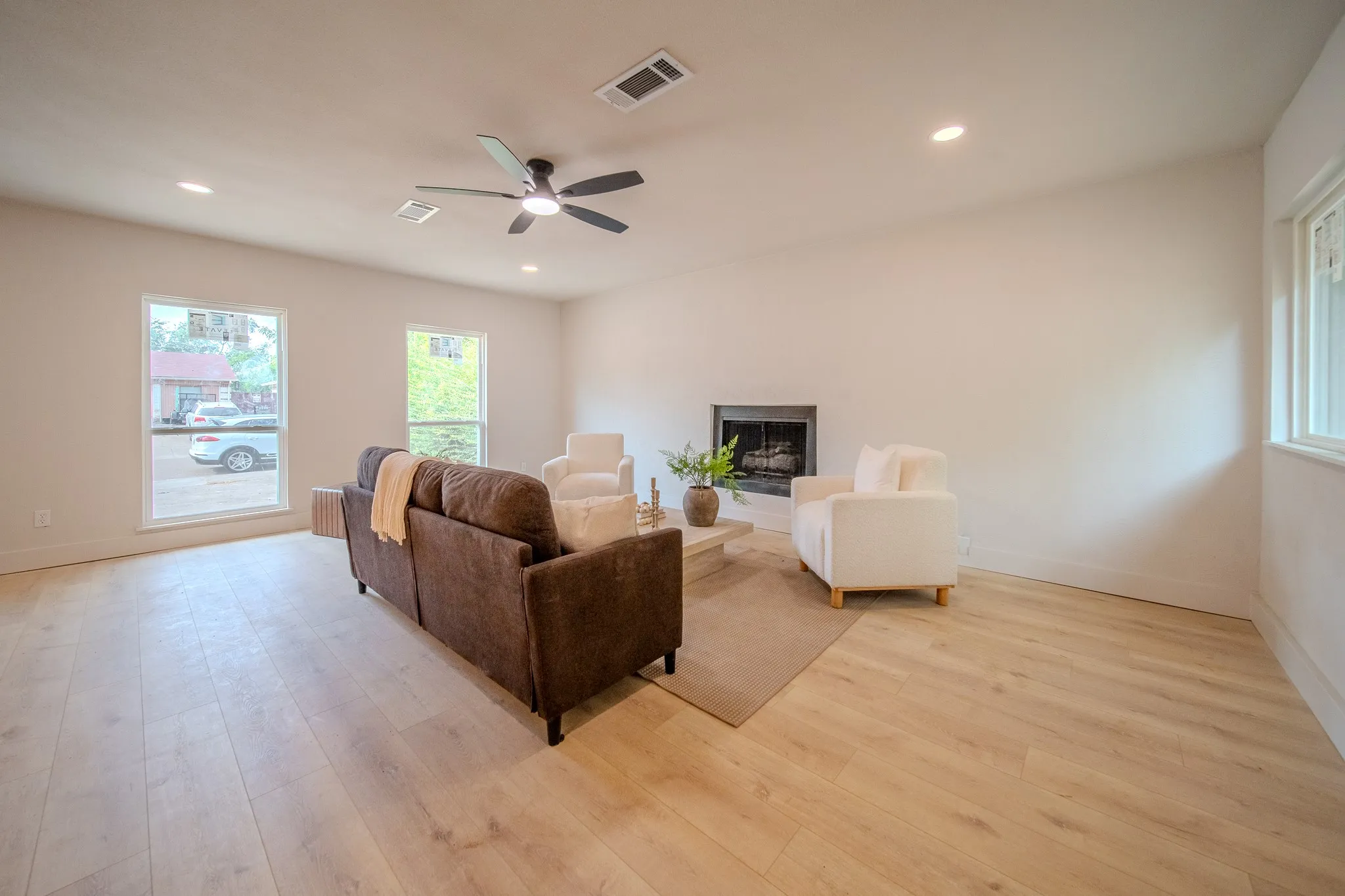 Recessed lighting, wood-finish flooring, ceiling fan, multiple windows, and a built-in fireplace