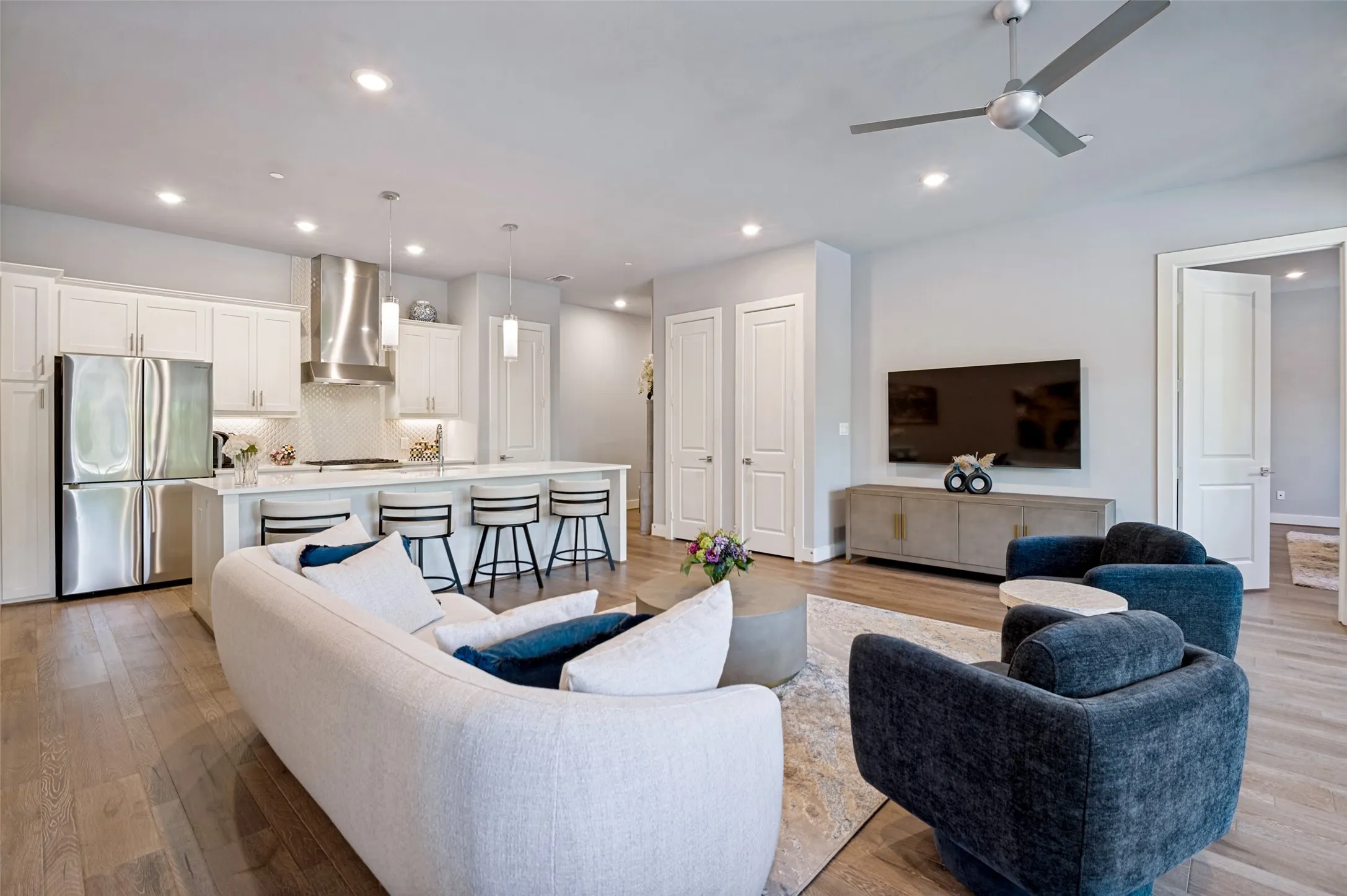 Open-concept living space featuring wood-finish flooring, recessed lighting, and a modern ceiling fan