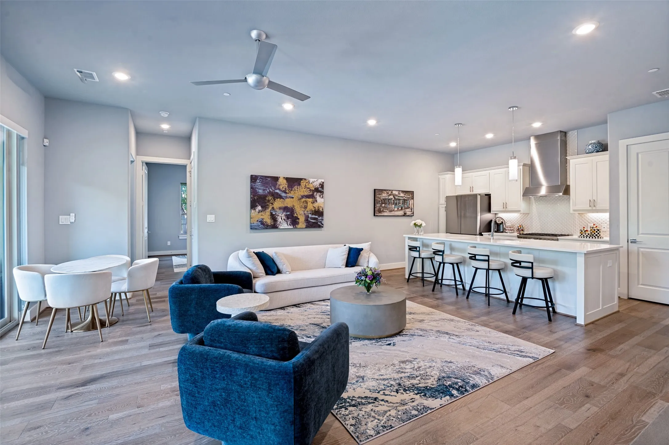 Open-concept living area featuring wood-finish flooring, recessed lighting, and a contemporary ceiling fan