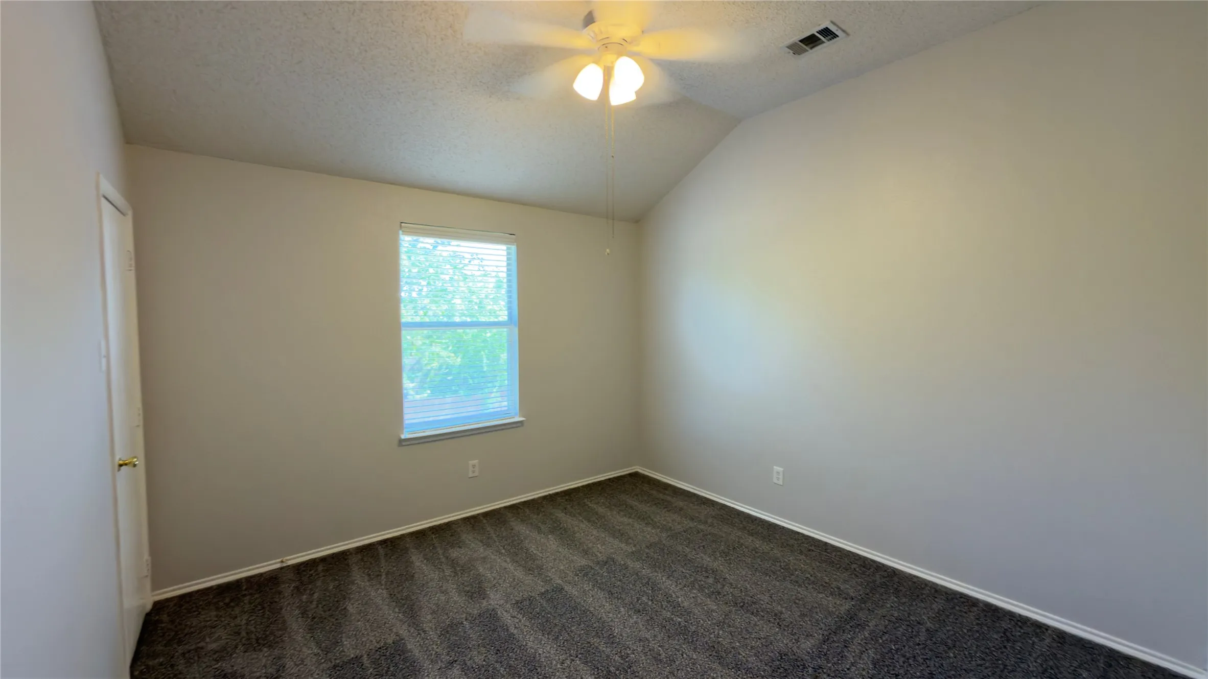 Vaulted ceiling with a ceiling fan, single window with blinds, and carpeted flooring