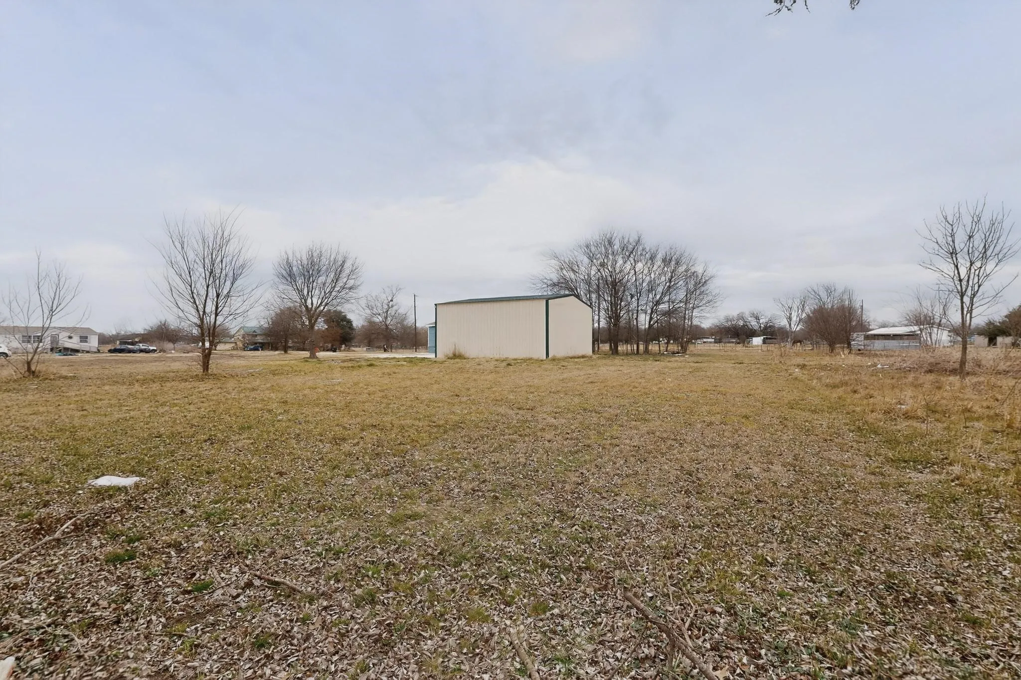 View of green lawn featuring an outbuilding and a pole building