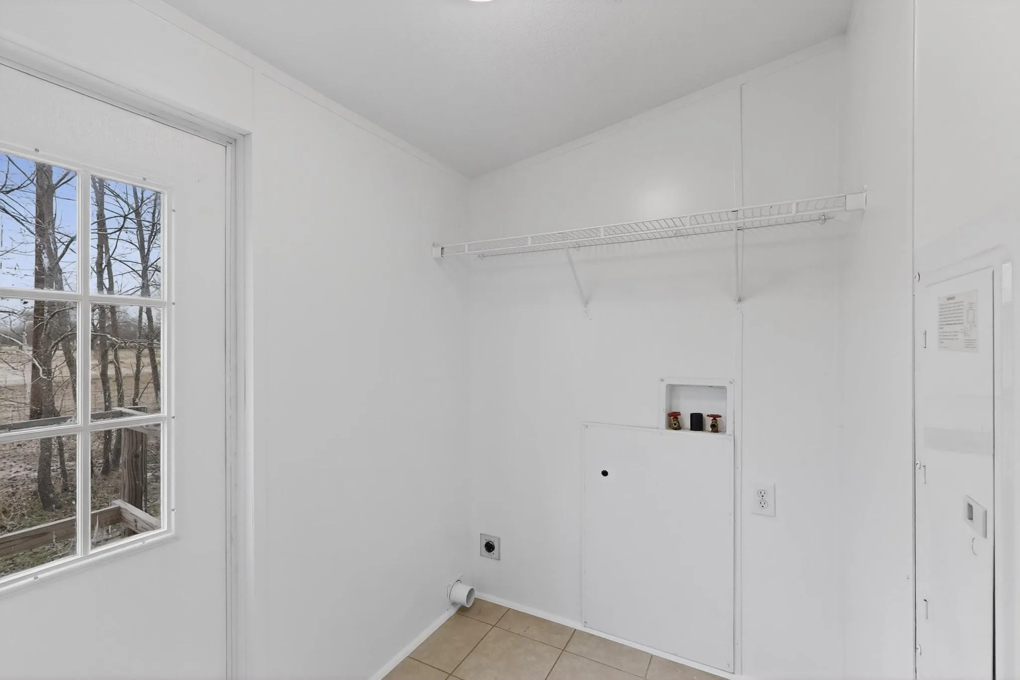 Laundry room featuring electric dryer hookup, washer hookup, and light tile patterned floors
