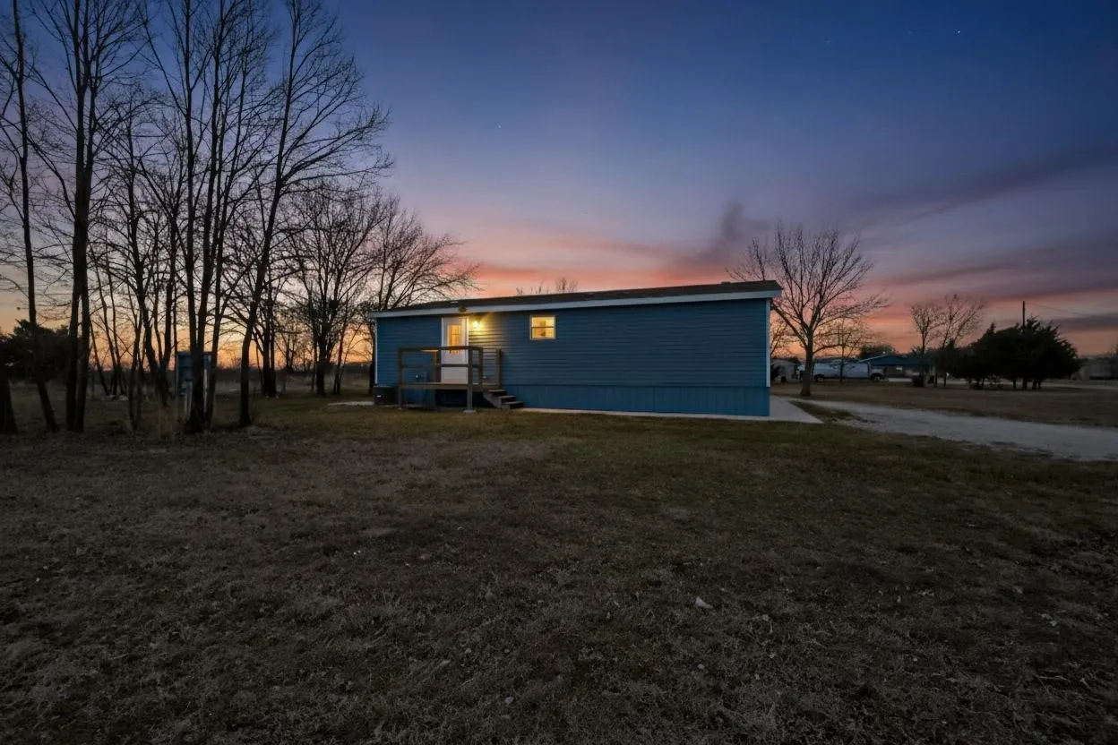 Rear view of property featuring a wooden deck and a lawn