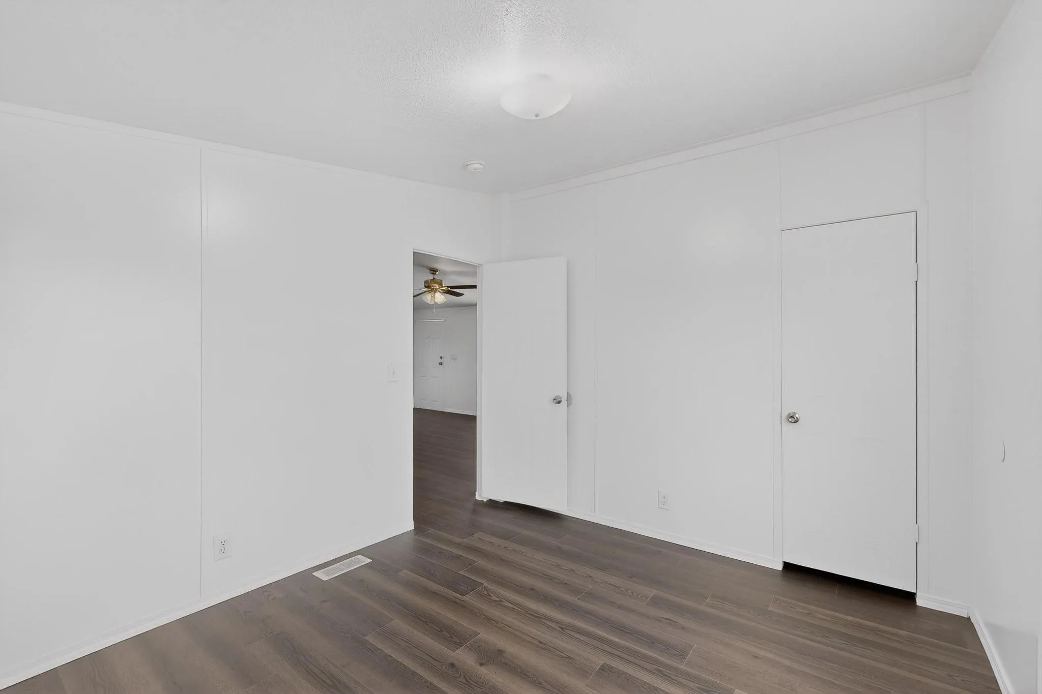 Unfurnished bedroom featuring dark wood-type flooring