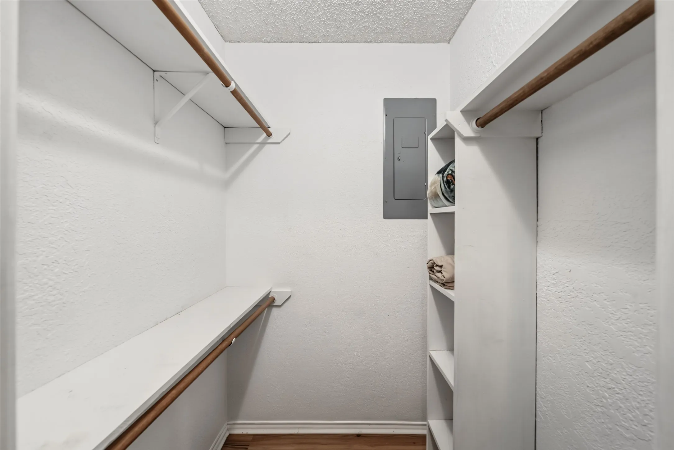 Walk-in closet with multiple hanging rods, built-in shelving