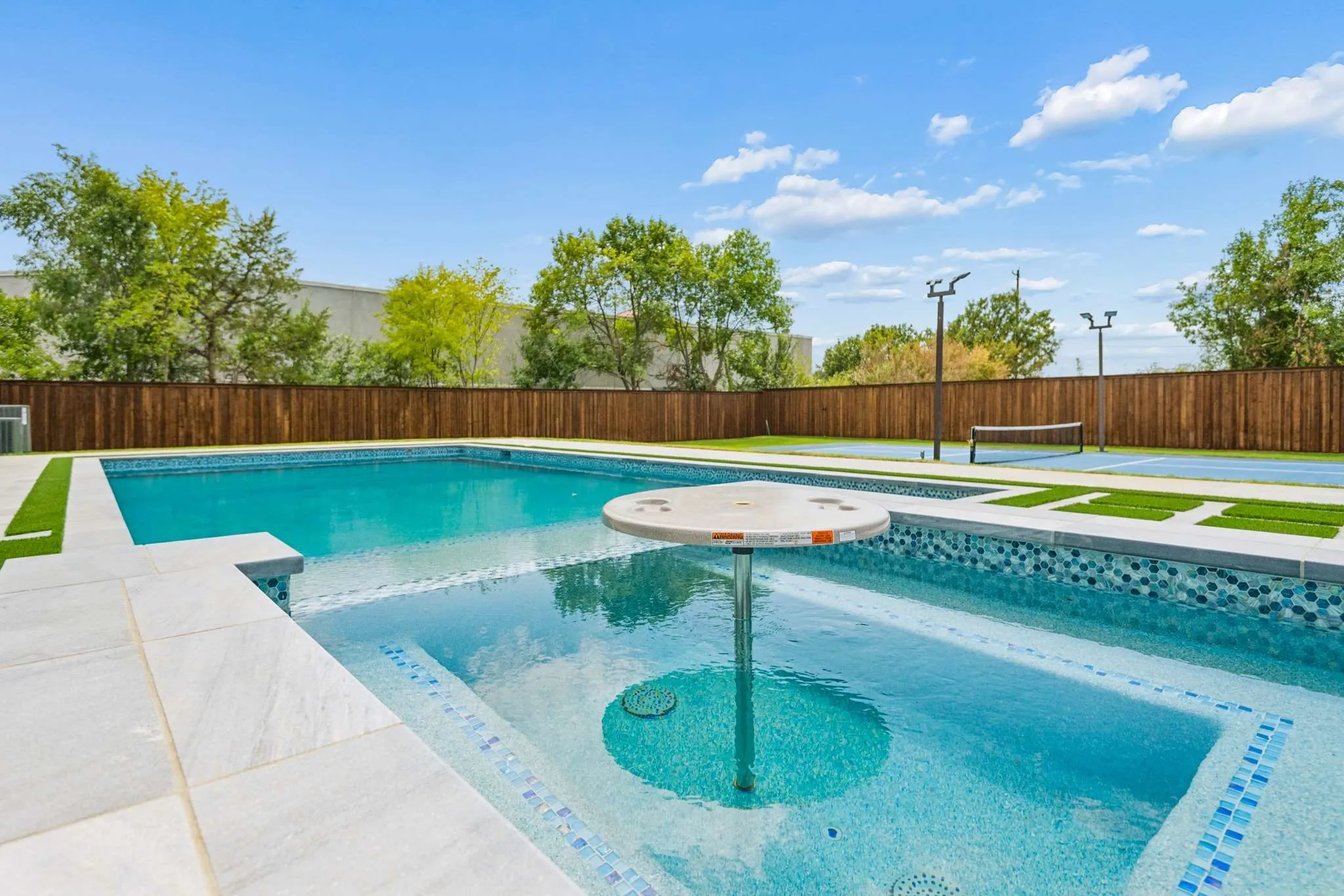 Swimming pool with integrated spa and in-pool table