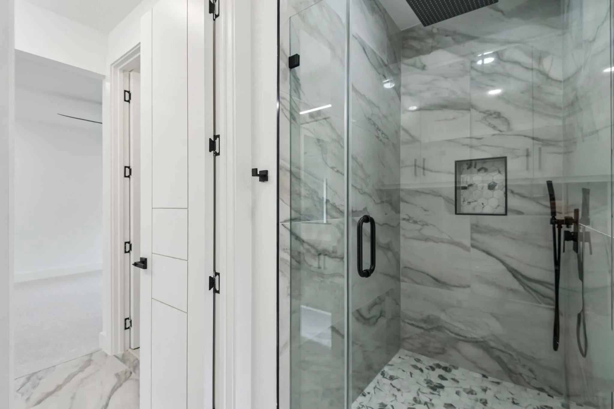 Glass-enclosed shower with a rainfall showerhead, tiled walls, and a mosaic floor
