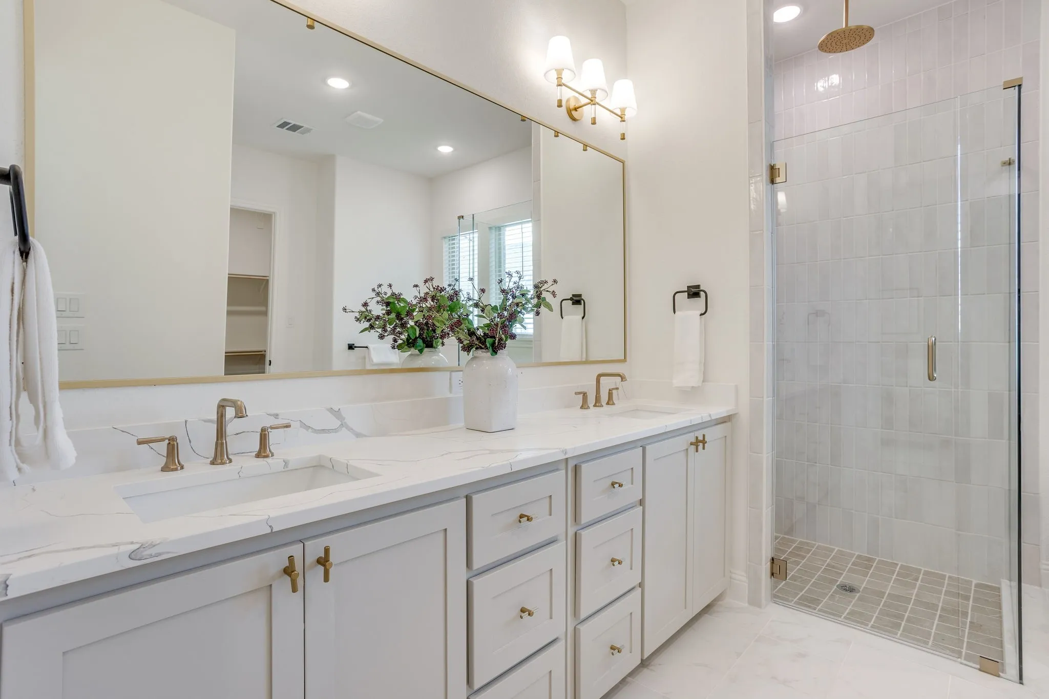Dual vanity with stone-finish countertop, undermount sinks, and brass-finish fixtures