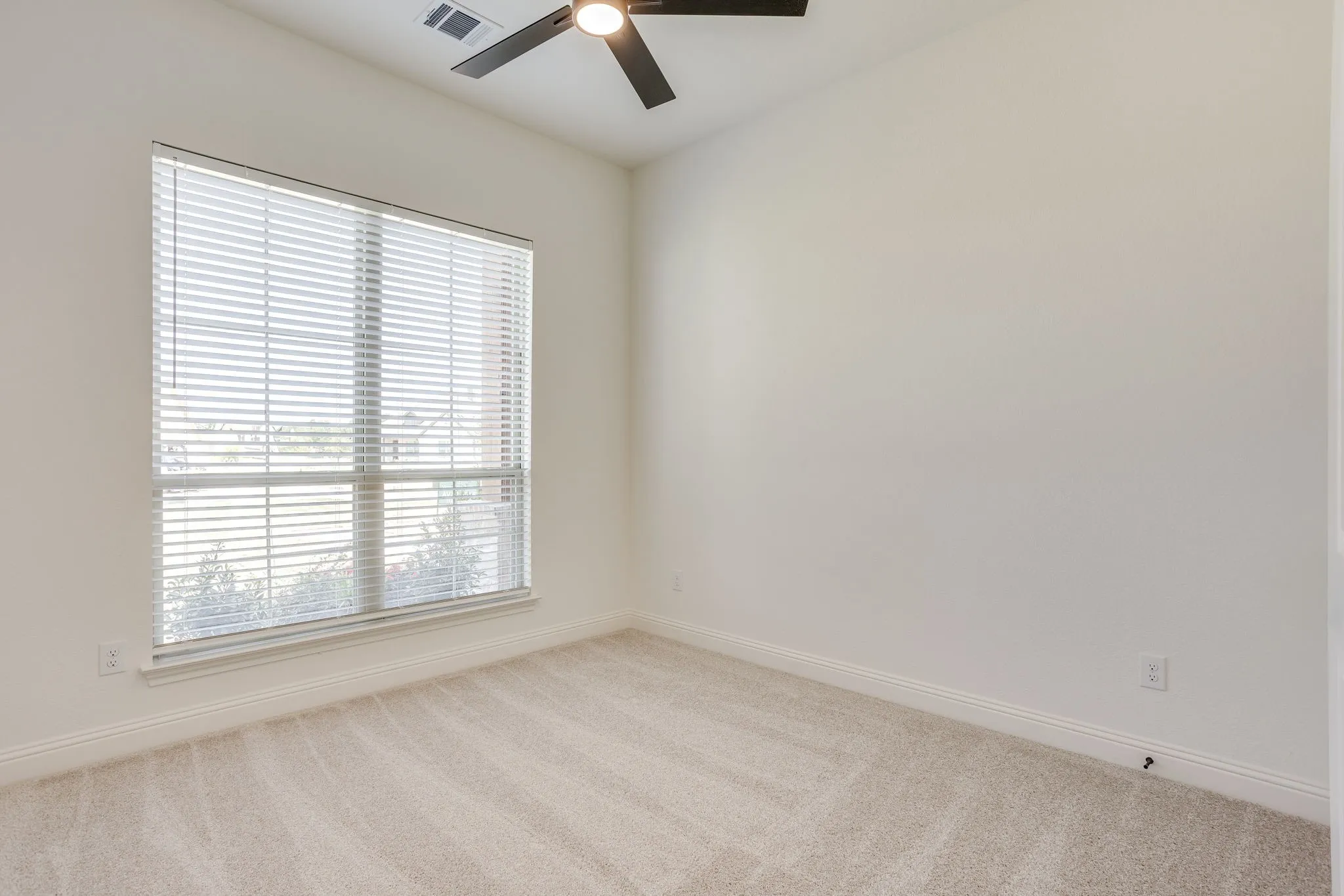 Secondary bedroom with ceiling fan and walk in closet