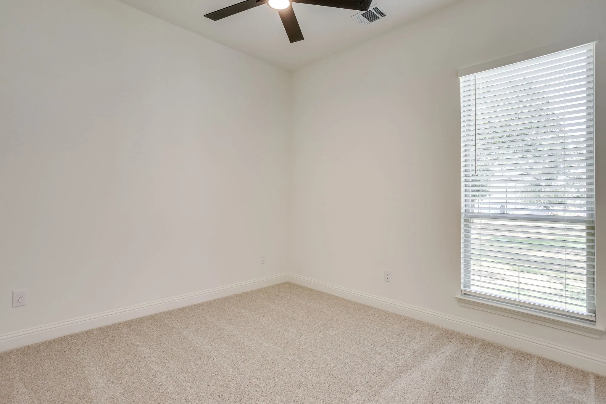 Secondary bedroom with ceiling fan and walk in closet