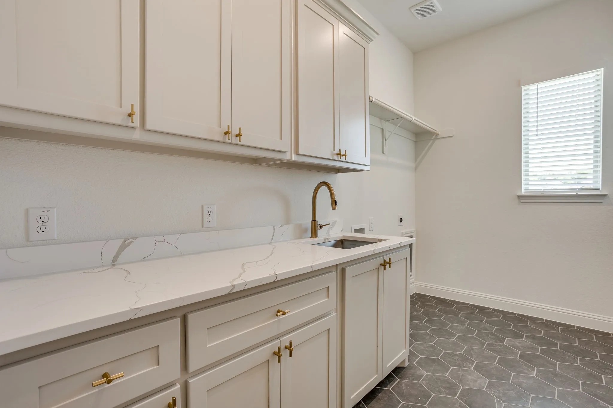 Custom cabinetry with sink and room for full sie washer and dryer