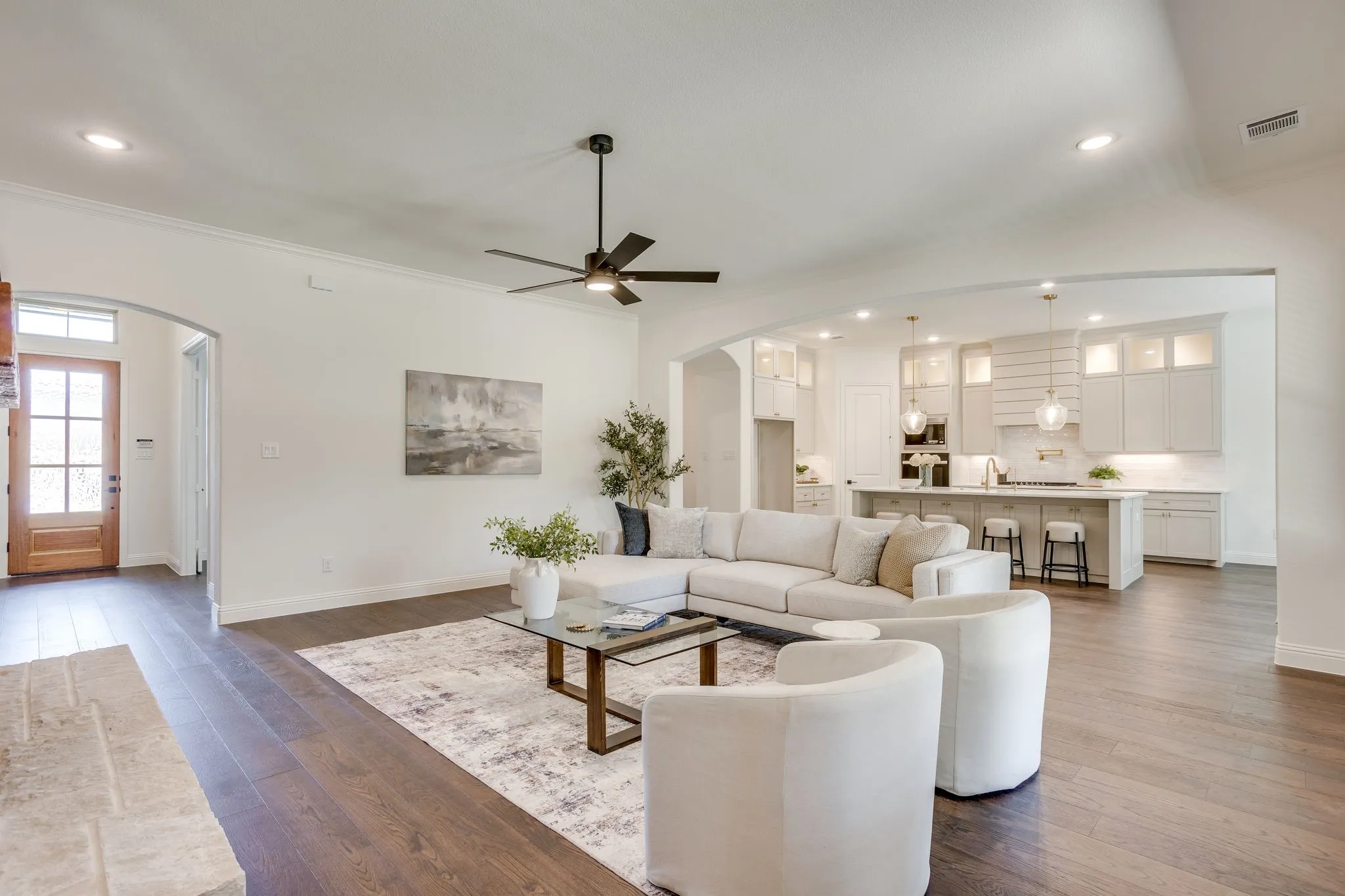 Spacious living area featuring wood-finish flooring, recessed lighting, and a modern ceiling fan