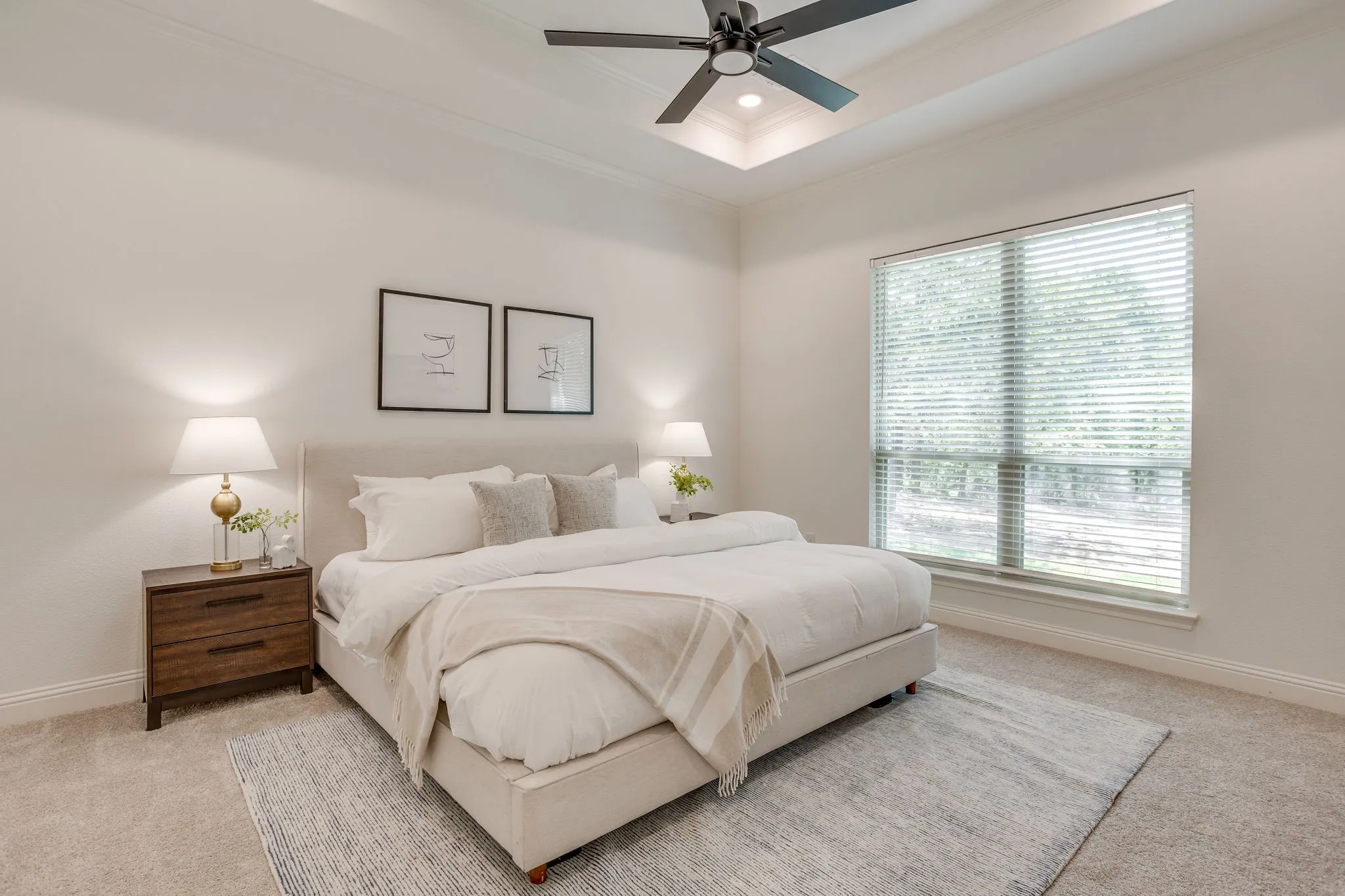 Tray ceiling with recessed lighting, ceiling fan, large window with blinds, and carpeted flooring