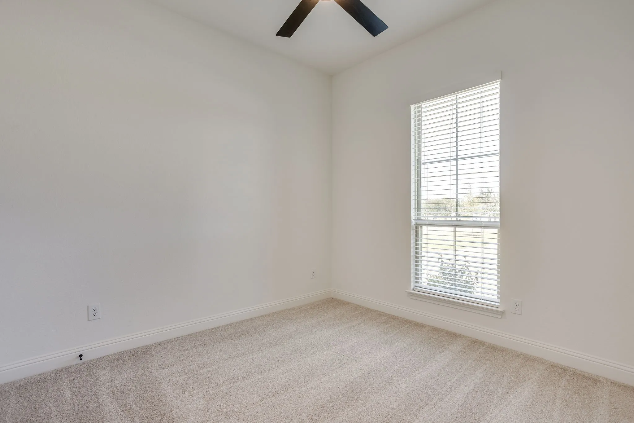 Secondary bedroom with ceiling fan and walk in closet